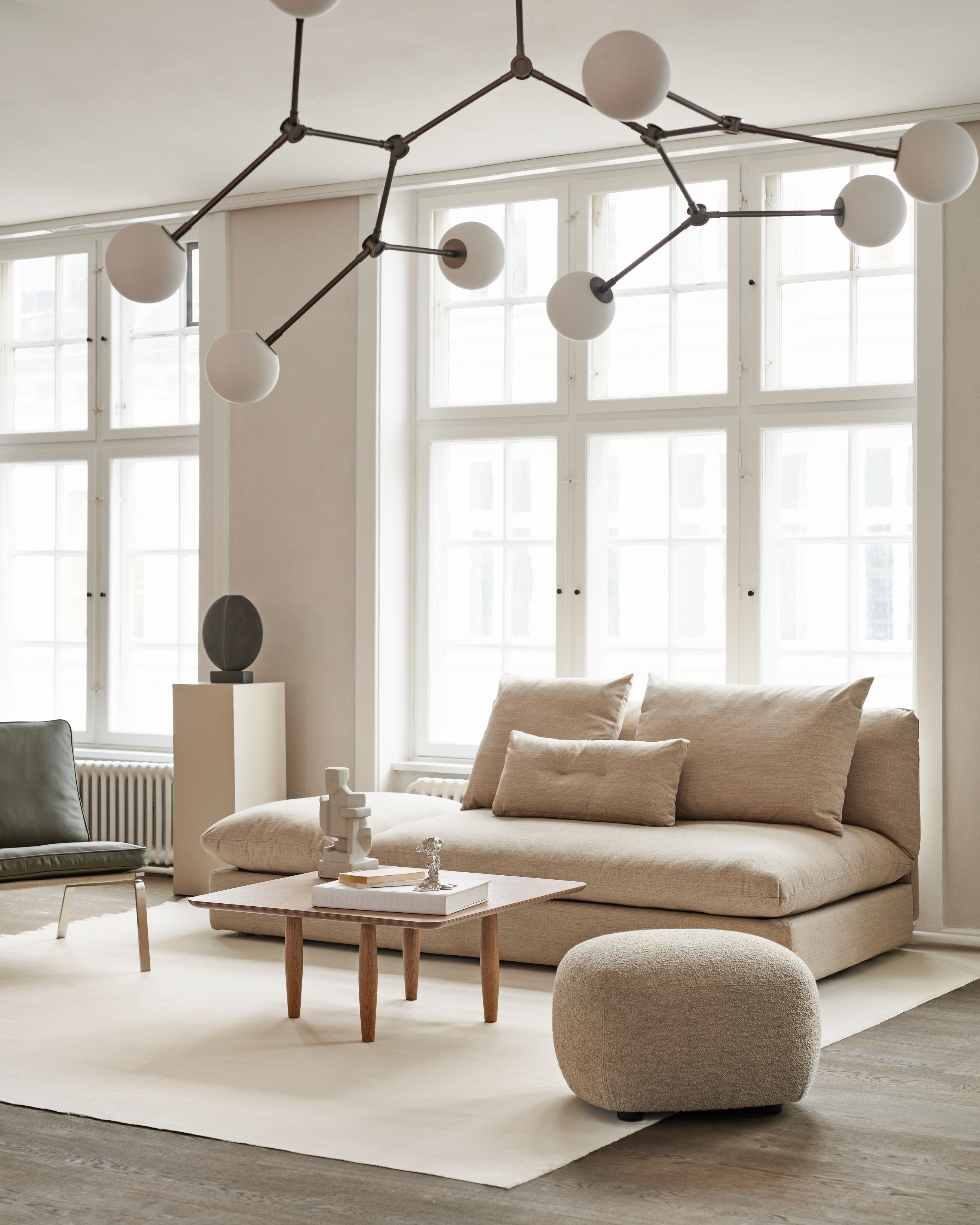 Oku Couchtisch Eiche Norr11 im Wohnzimmer mit Sofa, Sessel, Teppich und moderner Lampe.