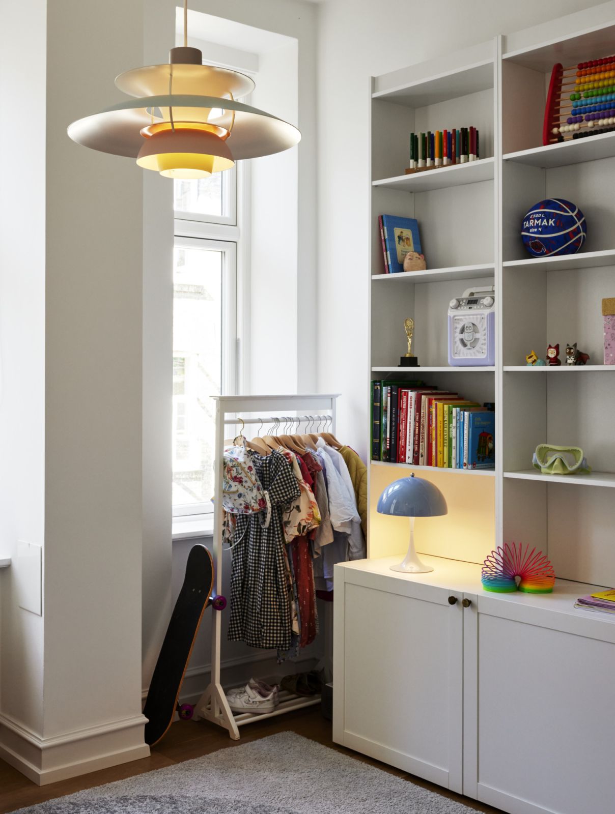 PH 5 Pendelleuchte von Louis Poulsen in einem Kinderzimmer mit Kleiderständer und Bücherregal.