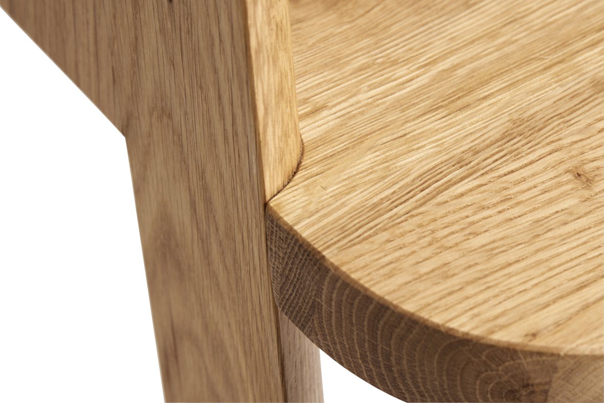 Detailaufnahme des Hay Butler Hockers aus hellem Eichenholz, Sitzfläche und Bein.