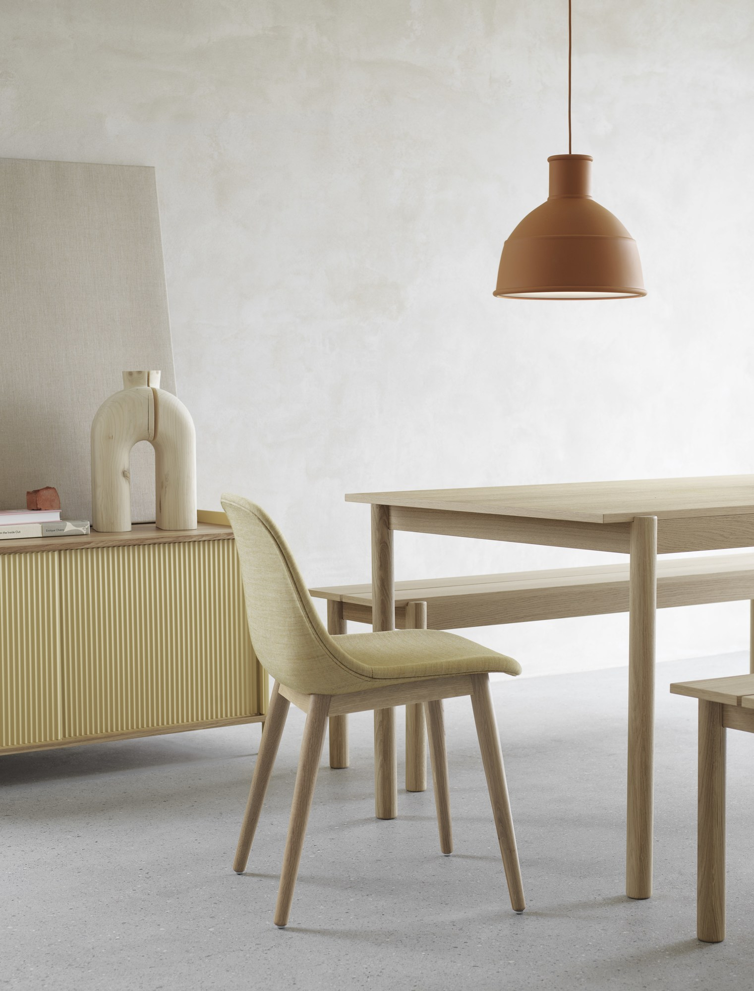 Gelbes Muuto Enfold Sideboard Low im modernen Esszimmer mit Tisch, Stuhl und Lampe.