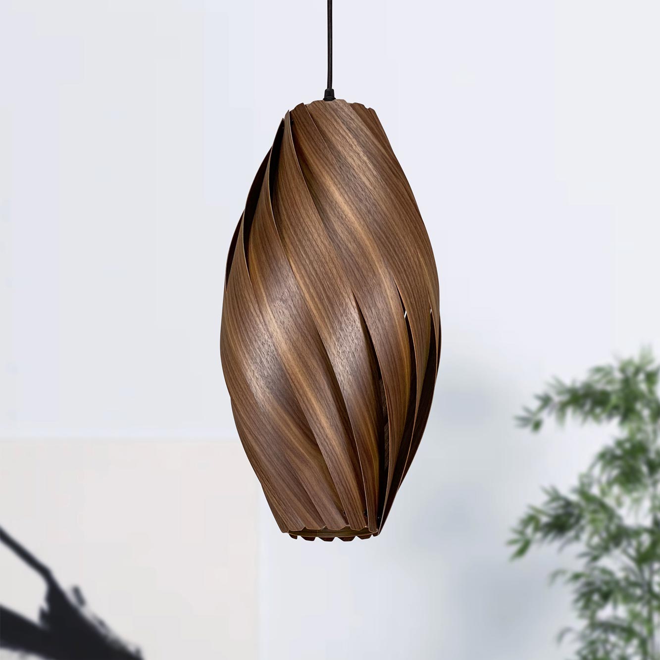 Ardére Hängeleuchte aus Nussbaumholz: Längliche Pendelleuchte mit gedrehtem Holzdesign für stilvolle Beleuchtung.