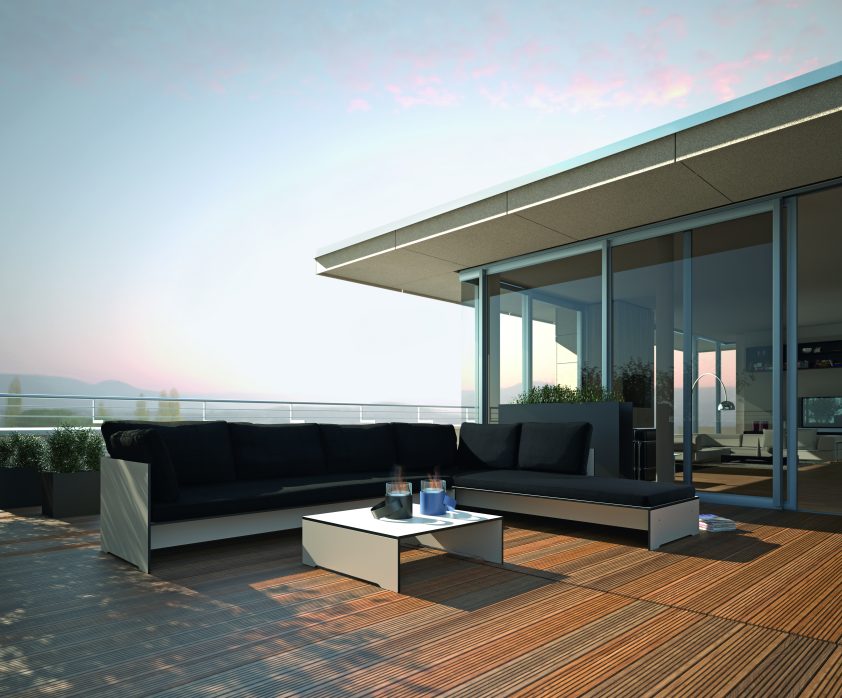 Riva Lounge Sofa von Conmoto auf einer Terrasse mit Holzboden und schwarzem Polster.