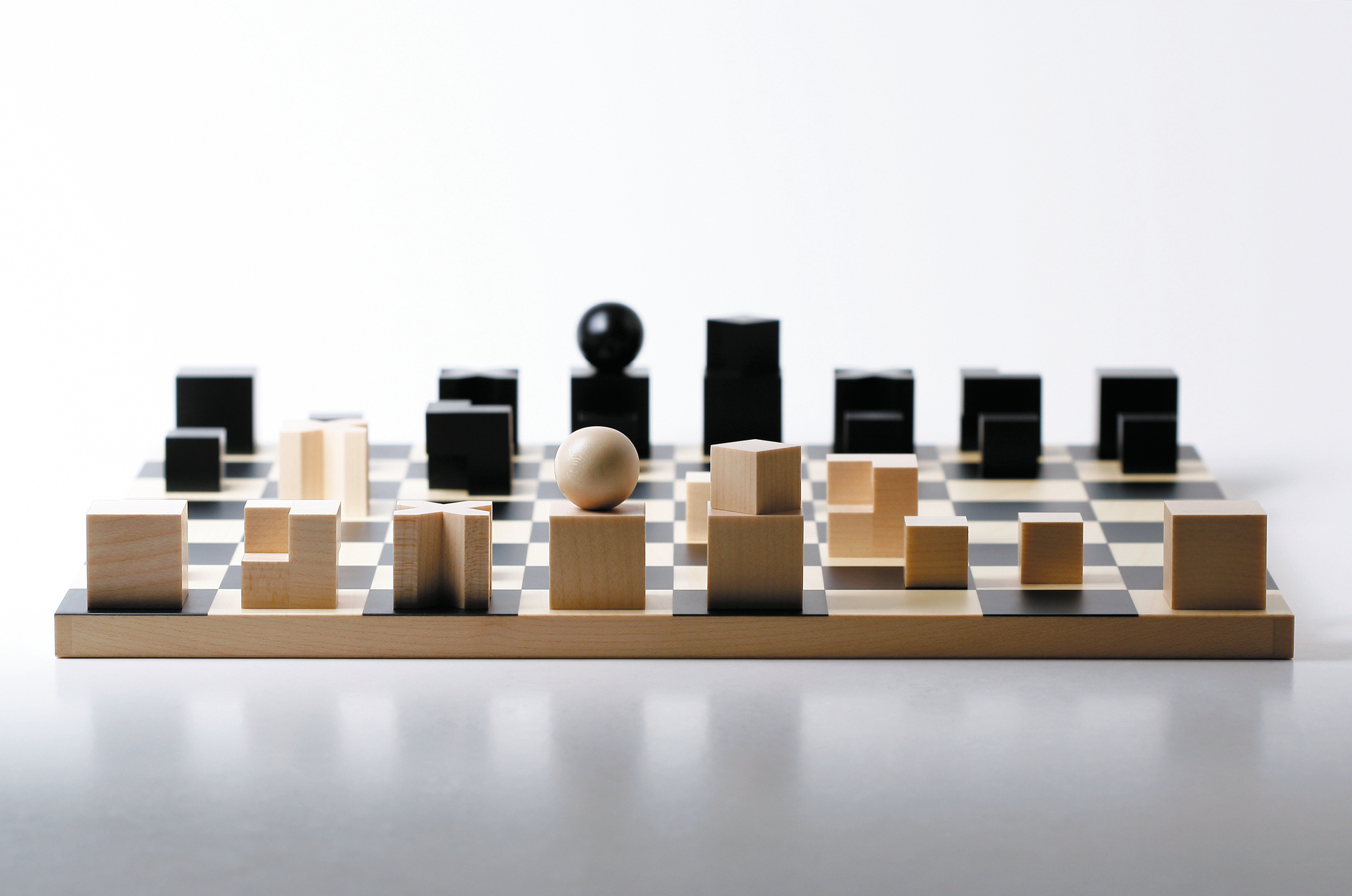 Bauhaus Schachbrett von Naef Spiele: Holzschachbrett mit abstrakten, geometrischen Schachfiguren in Schwarz und Naturholz.