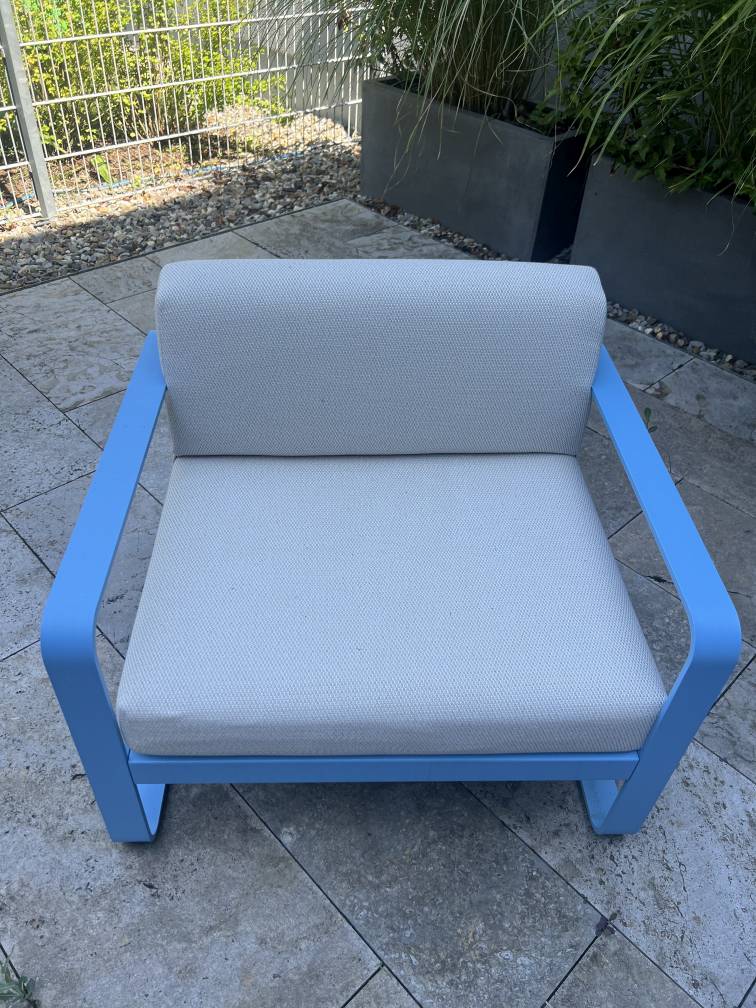 Blauer Bellevie Outdoor Lounge Sessel mit hellgrauen Kissen, moderne Gartenmöbel für Terrasse und Balkon.