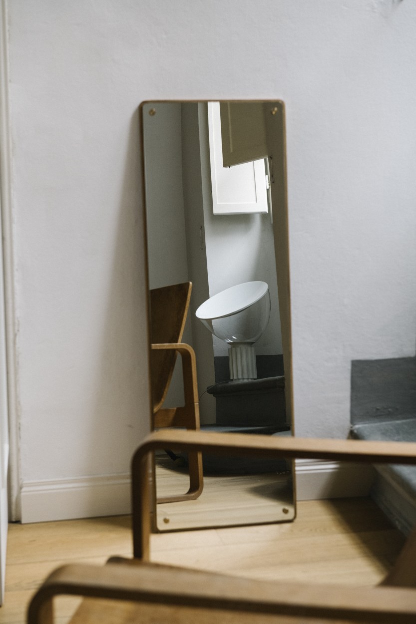 Spiegelbild einer Taccia LED Tischleuchte von Flos, weiße Glasleuchte mit modernem Design.