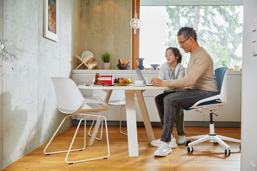 Numo Task Bürodrehstuhl von Aeris im Einsatz: Vater und Sohn arbeiten am Laptop am Esstisch.