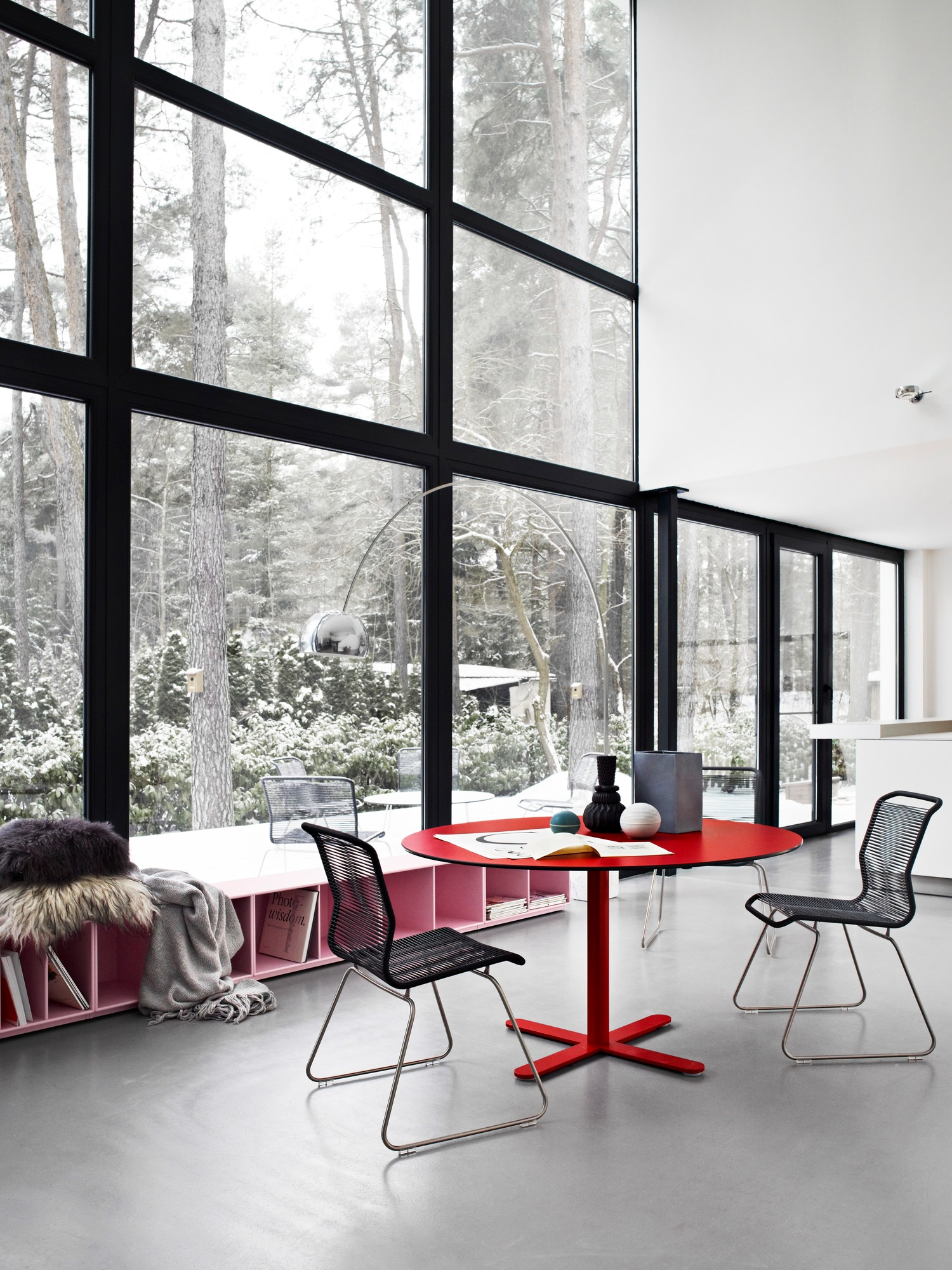 Panton One Dining Stuhl Outdoor Clark, Edelstahlgestell, vor großem Fenster mit Winterlandschaft, roter Tisch.