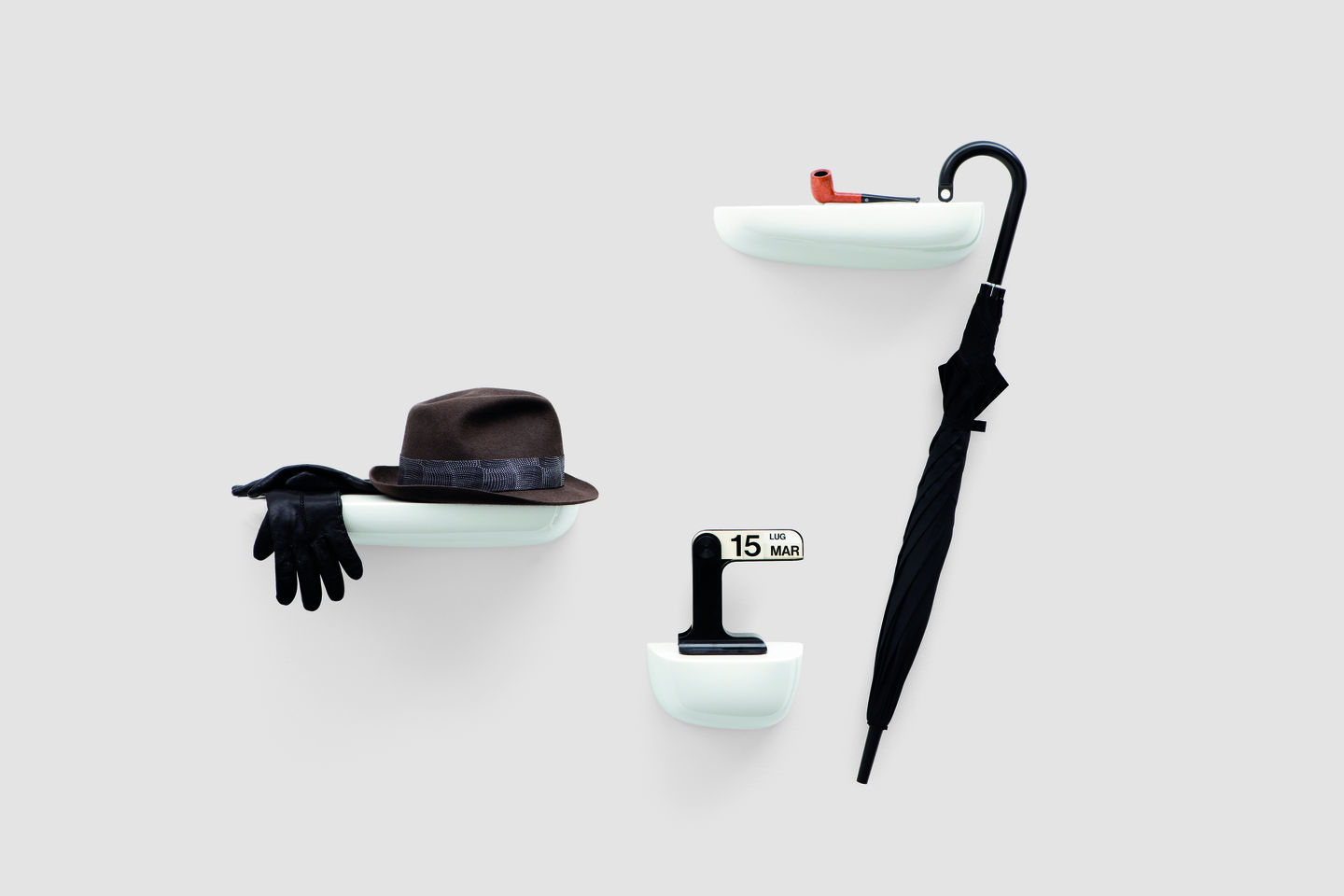 Vitra Corniches Wandboard Large in Weiß mit Hut, Handschuhen, Pfeife und Regenschirm an der Wand.