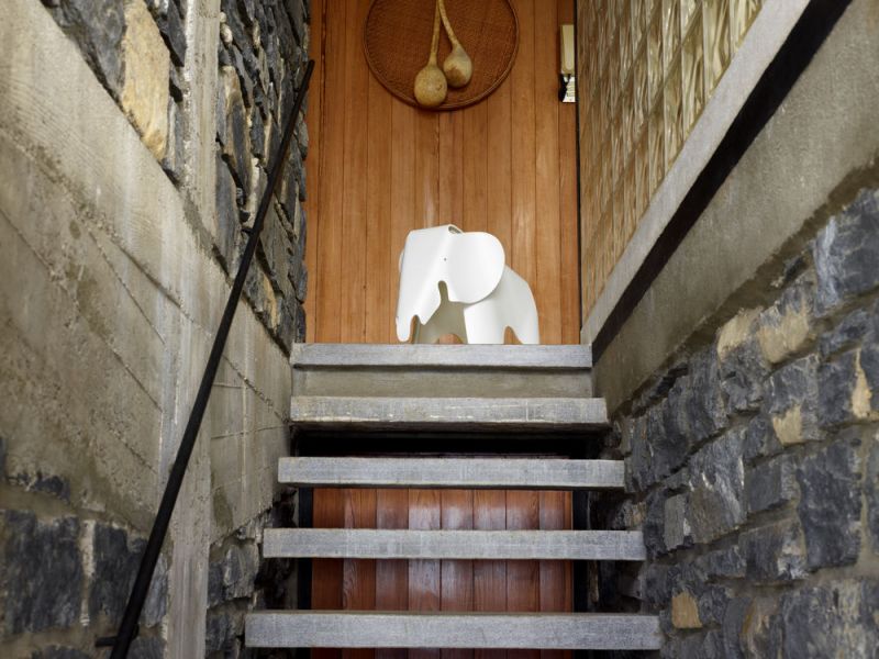 Weißer Deko-Elefant aus Kunststoff auf Steinstufen vor einer Holztür, moderne Wohnaccessoires und Dekoration.