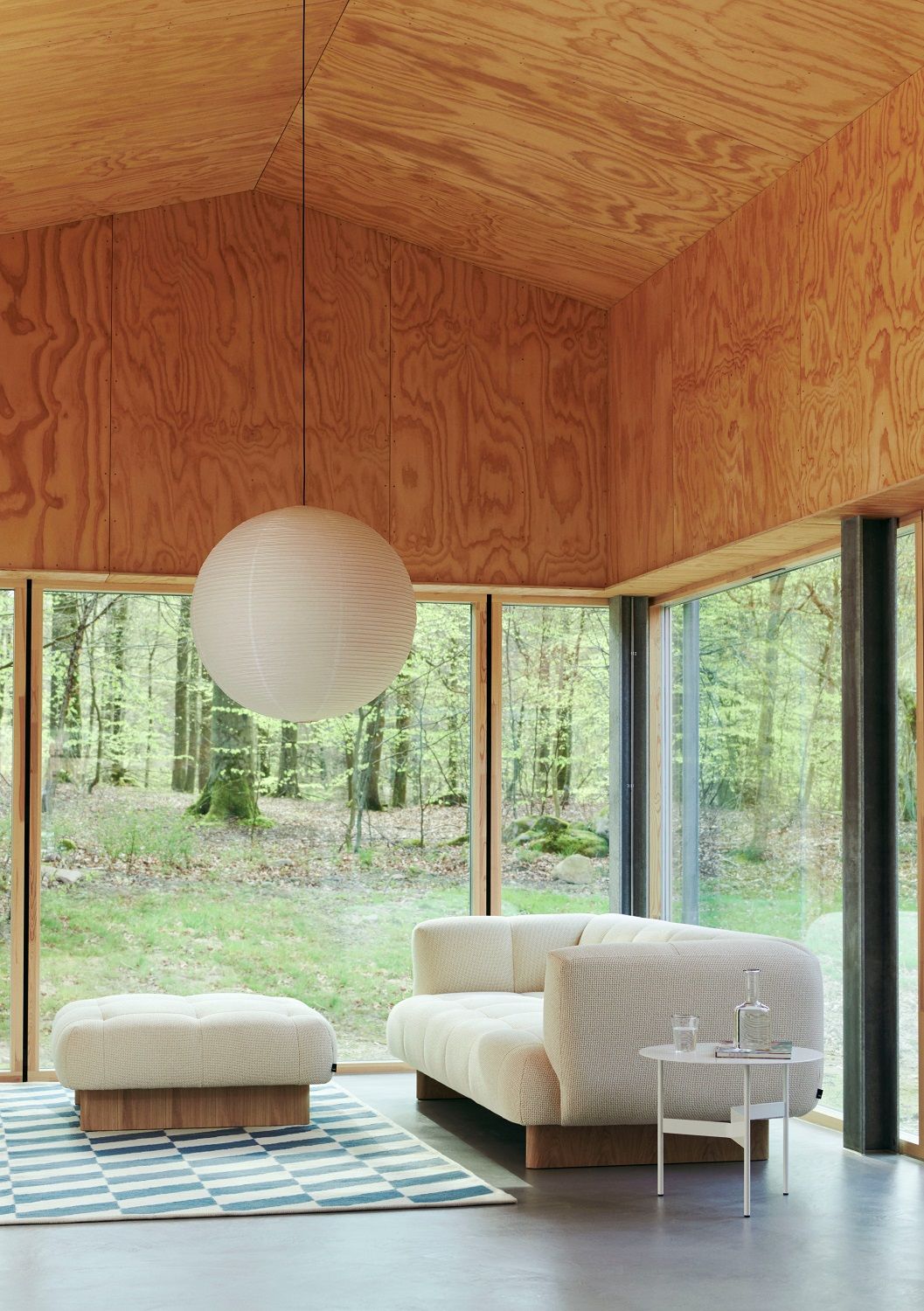 Heller Wohnraum mit Hay Quilton Lift Sofa 2-Sitzer, passendem Hocker und Blick in die Natur.
