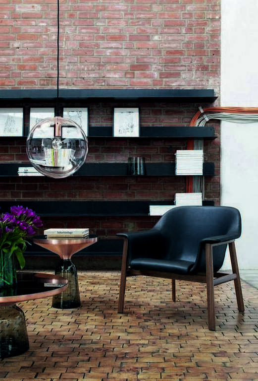 Bell Coffee Table Couchtisch Special Edition Kupfer ClassiCon vor Backsteinwand und Sessel.