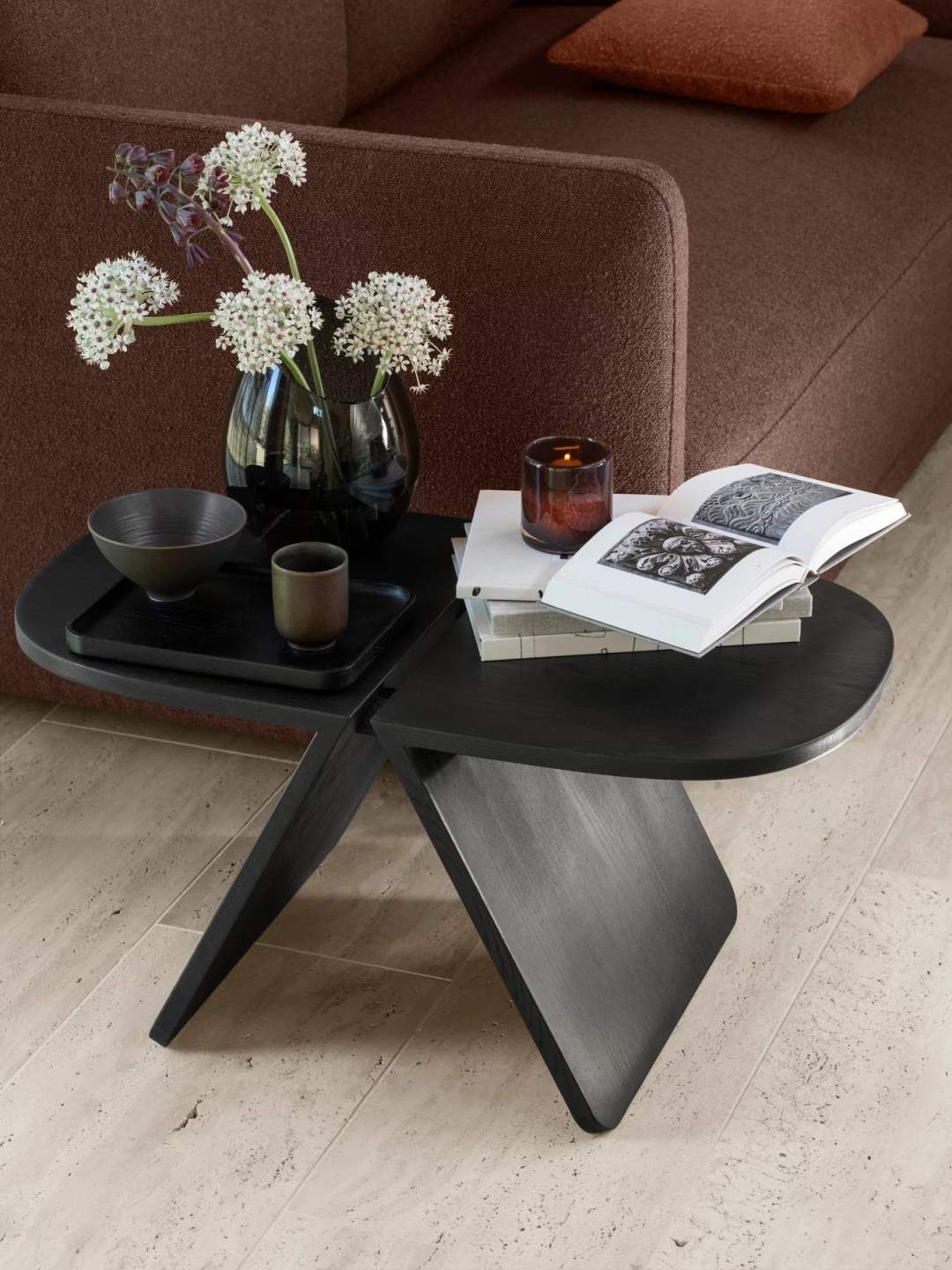 Avio Beistelltisch aus Eiche in Schwarz von Blomus mit Deko-Elementen auf einem Sofa.