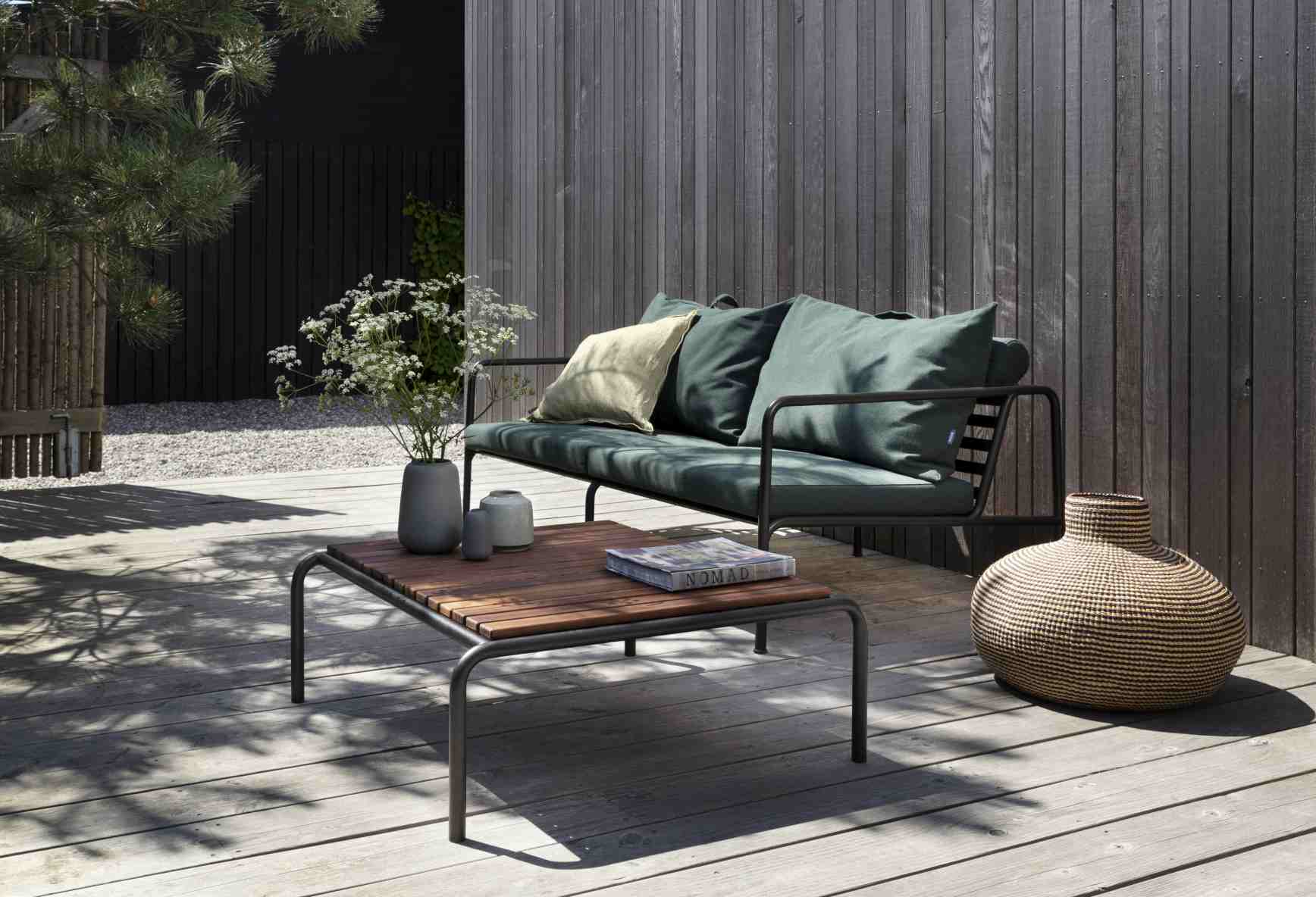 Avon Lounge Table Outdoor Tisch von Houe aus Holz und Metall mit Sofa im Garten.