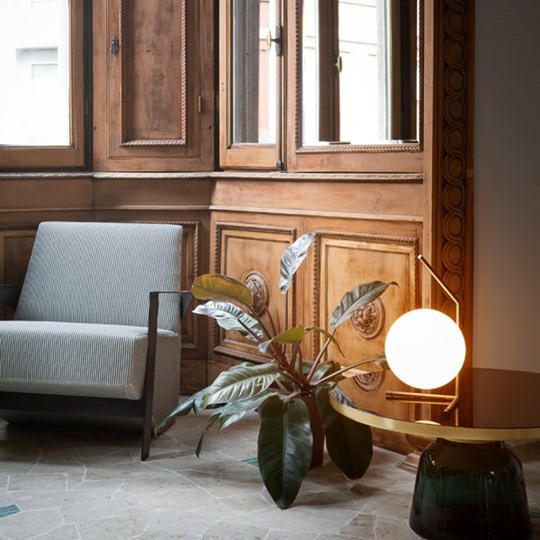 IC Lights T1 Low Tischleuchte von Flos: Moderne Kugel-Tischlampe aus Messing und Glas auf Beistelltisch.