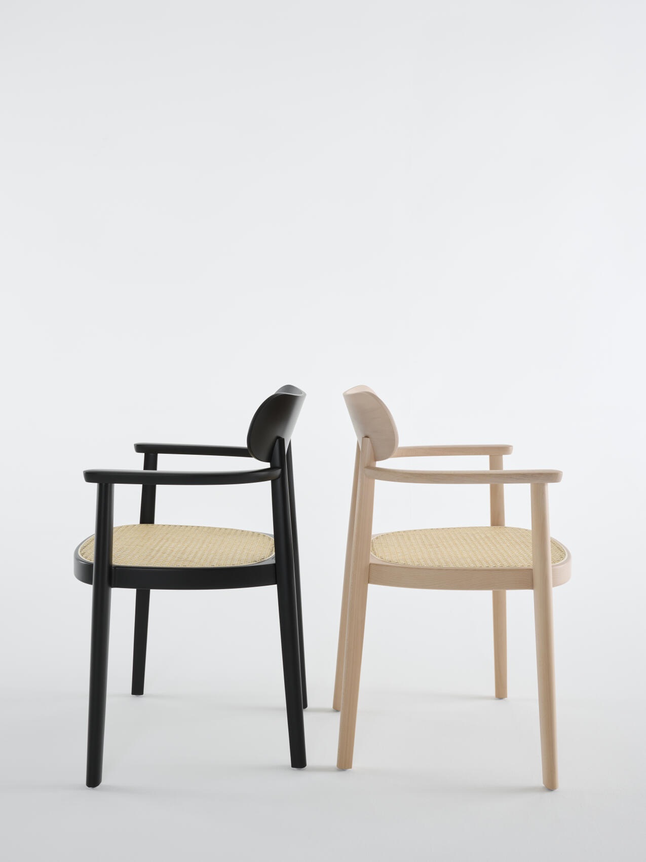Zwei 118 FV Holzstühle mit Armlehnen von Thonet, einer schwarz, einer naturfarben, mit Wiener Geflecht.