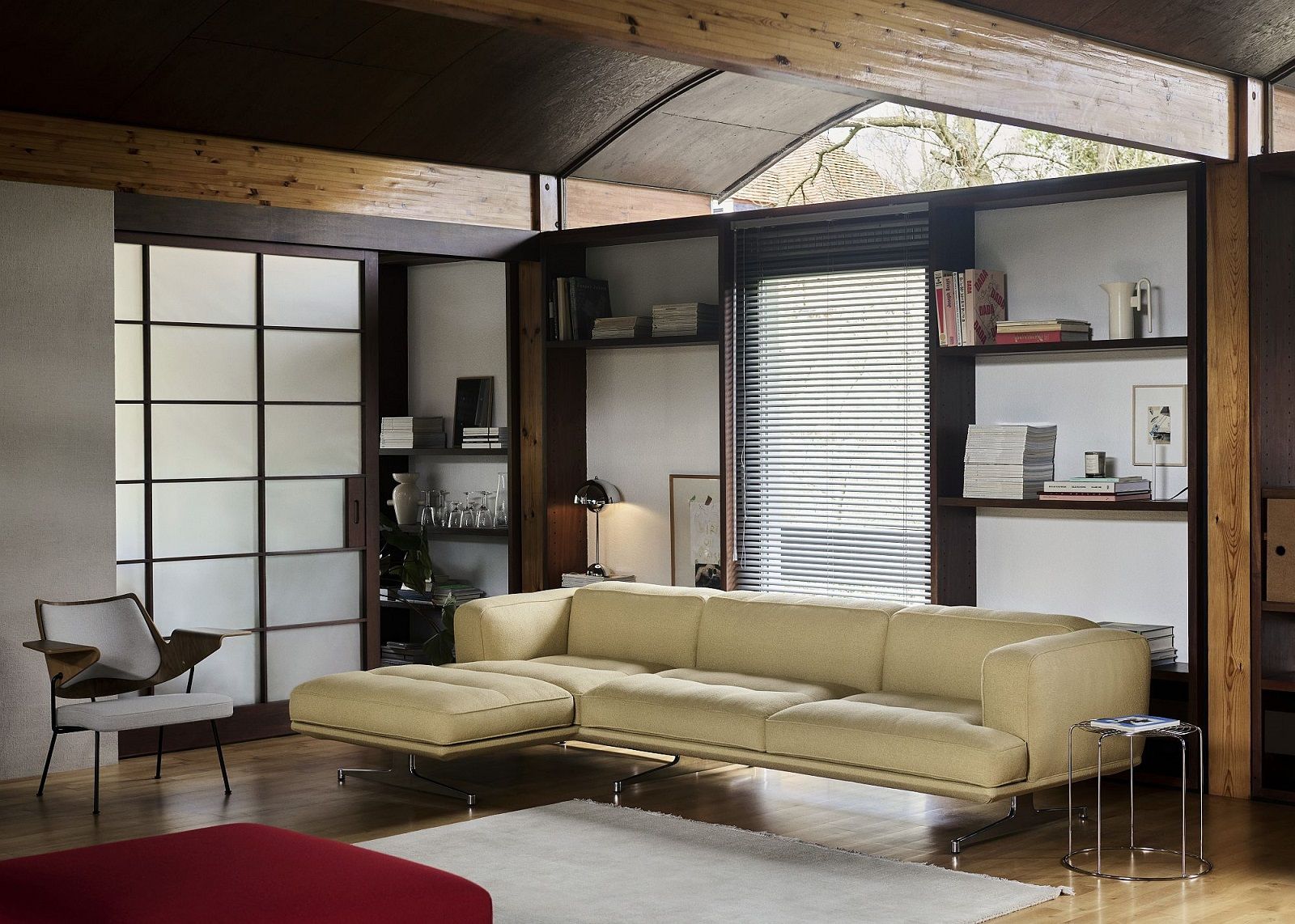 Beige Inland AV41 Sofa von AndTradition im modernen Wohnzimmer mit Bücherregal und Tageslicht.