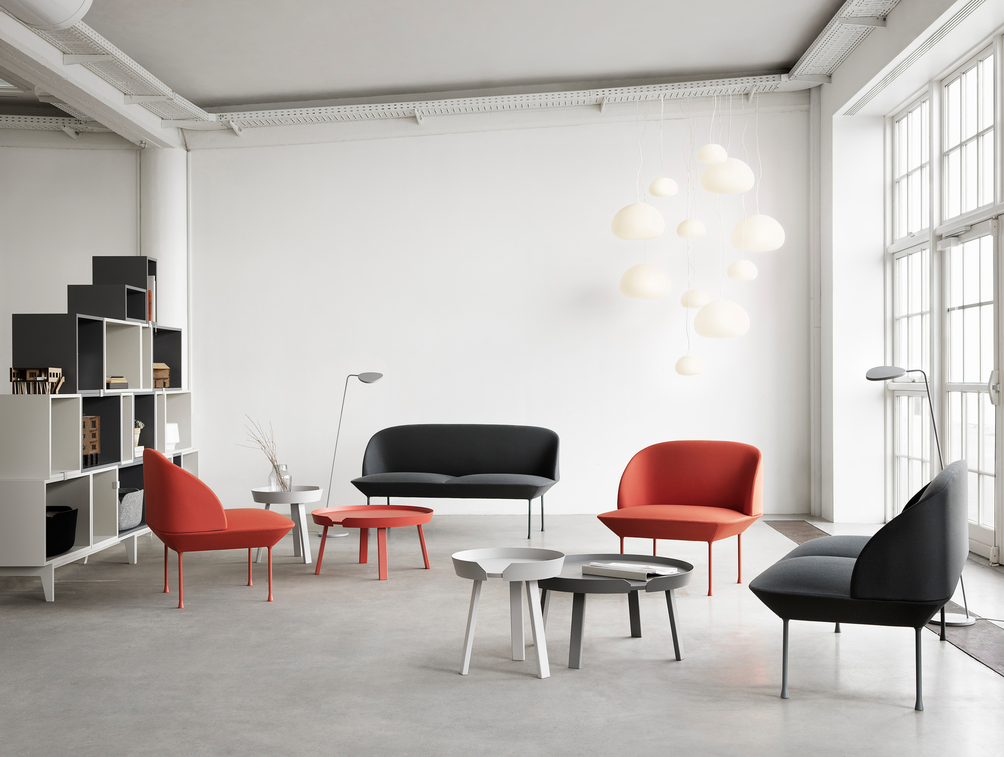 Helles Wohnzimmer mit Muuto Around Coffee Table Small Beistelltischen in Grau, Rot und Weiß.