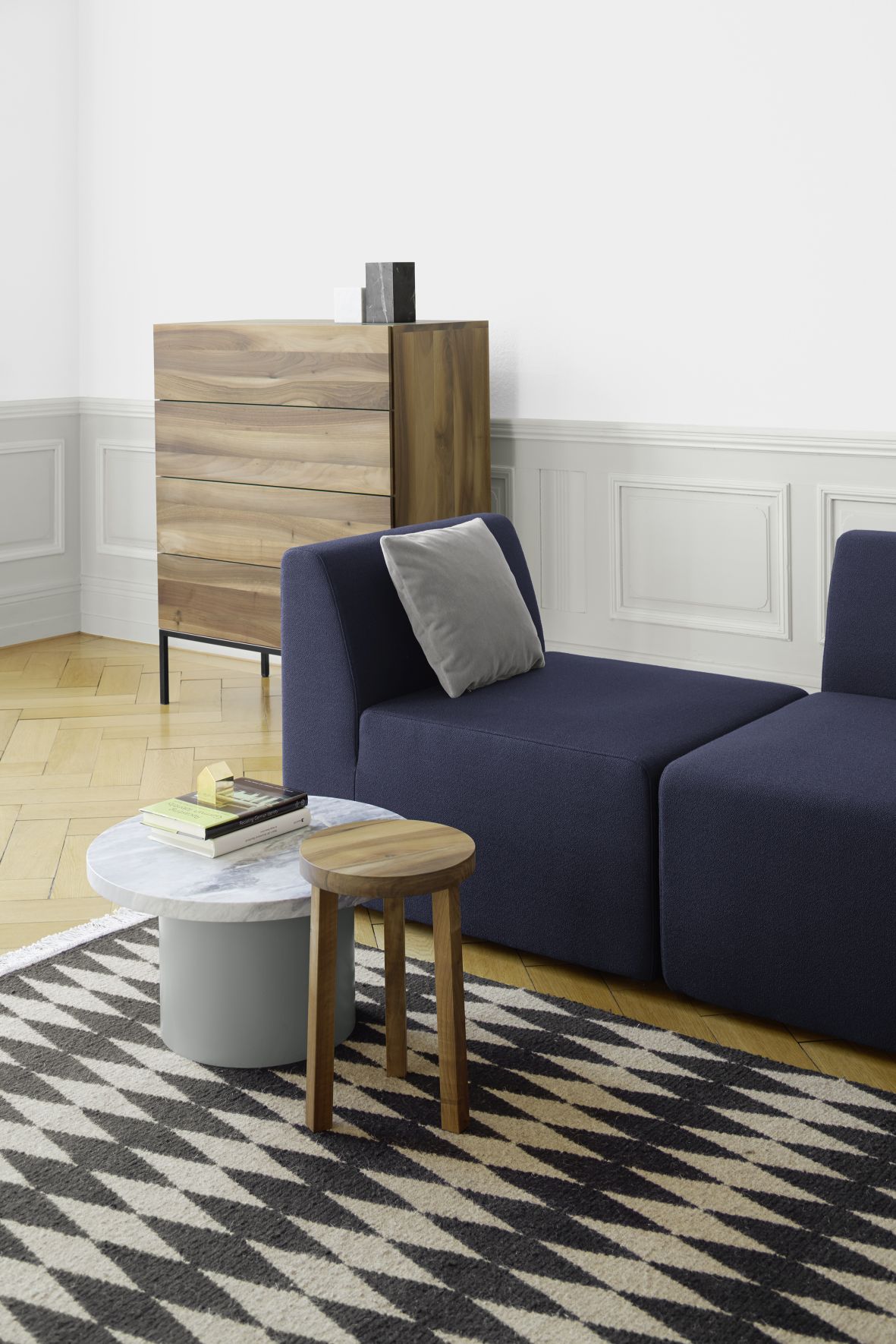 Enoki CT09 Beistelltisch e15 aus Holz neben Sofa und Marmor-Couchtisch auf gemustertem Teppich.
