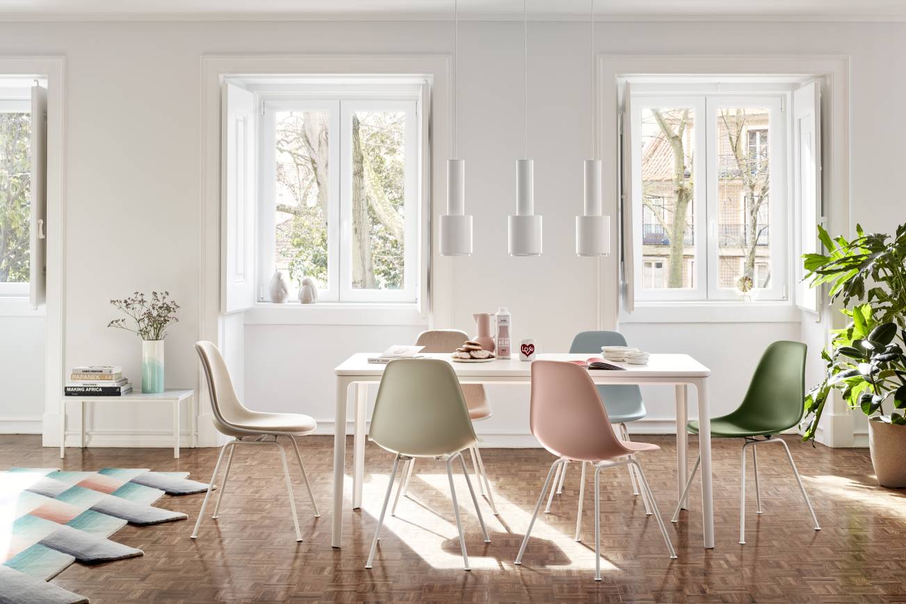 Helles Esszimmer mit Vitra Eames Plastic Chairs und einer Tripod Clock Tischuhr auf dem Esstisch.