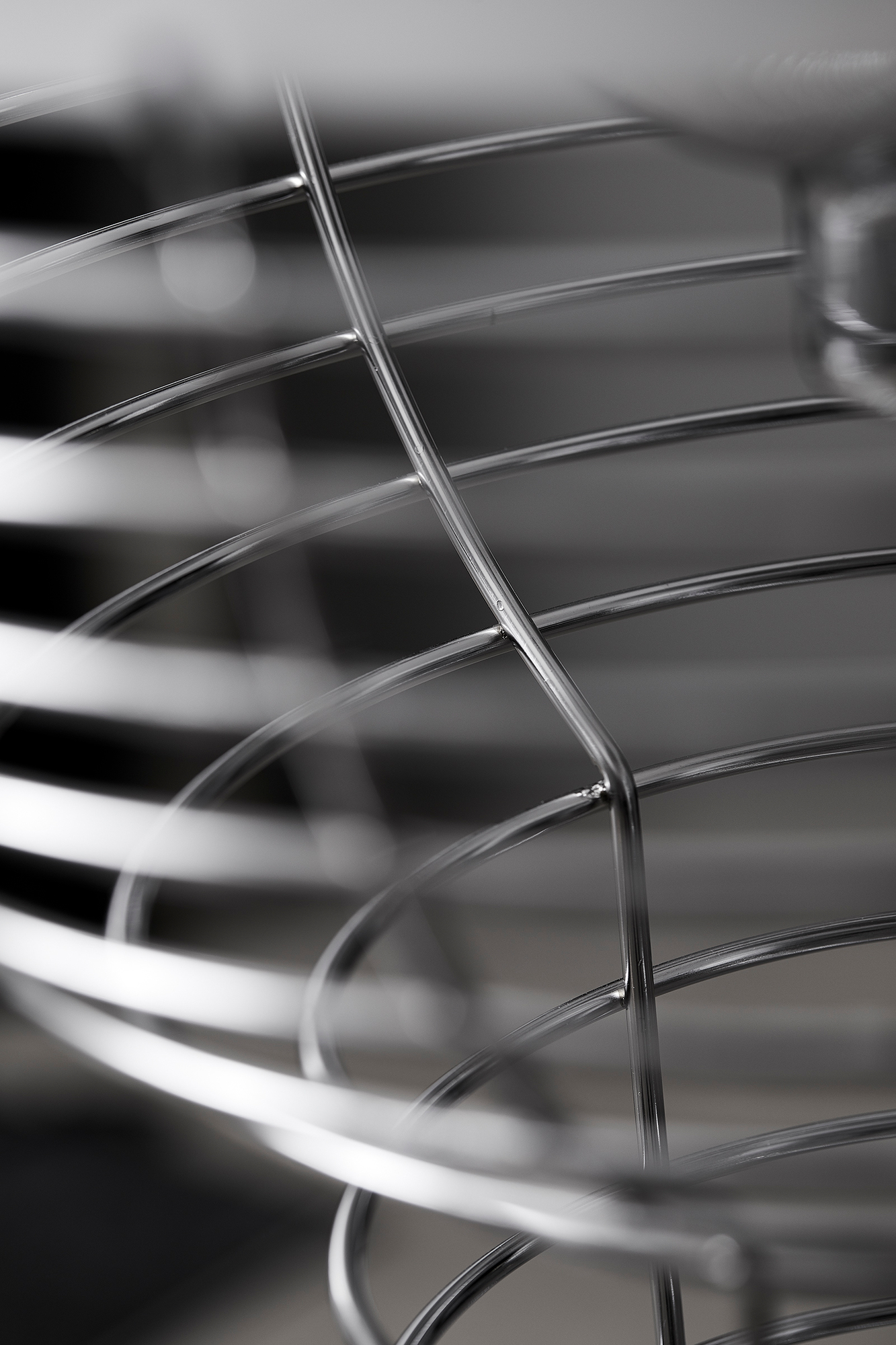 Detailaufnahme der Verpan Wire Stehleuchte: Filigrane, verchromte Metallstruktur mit verschwommenem Hintergrund für moderne Raumbeleuchtung.