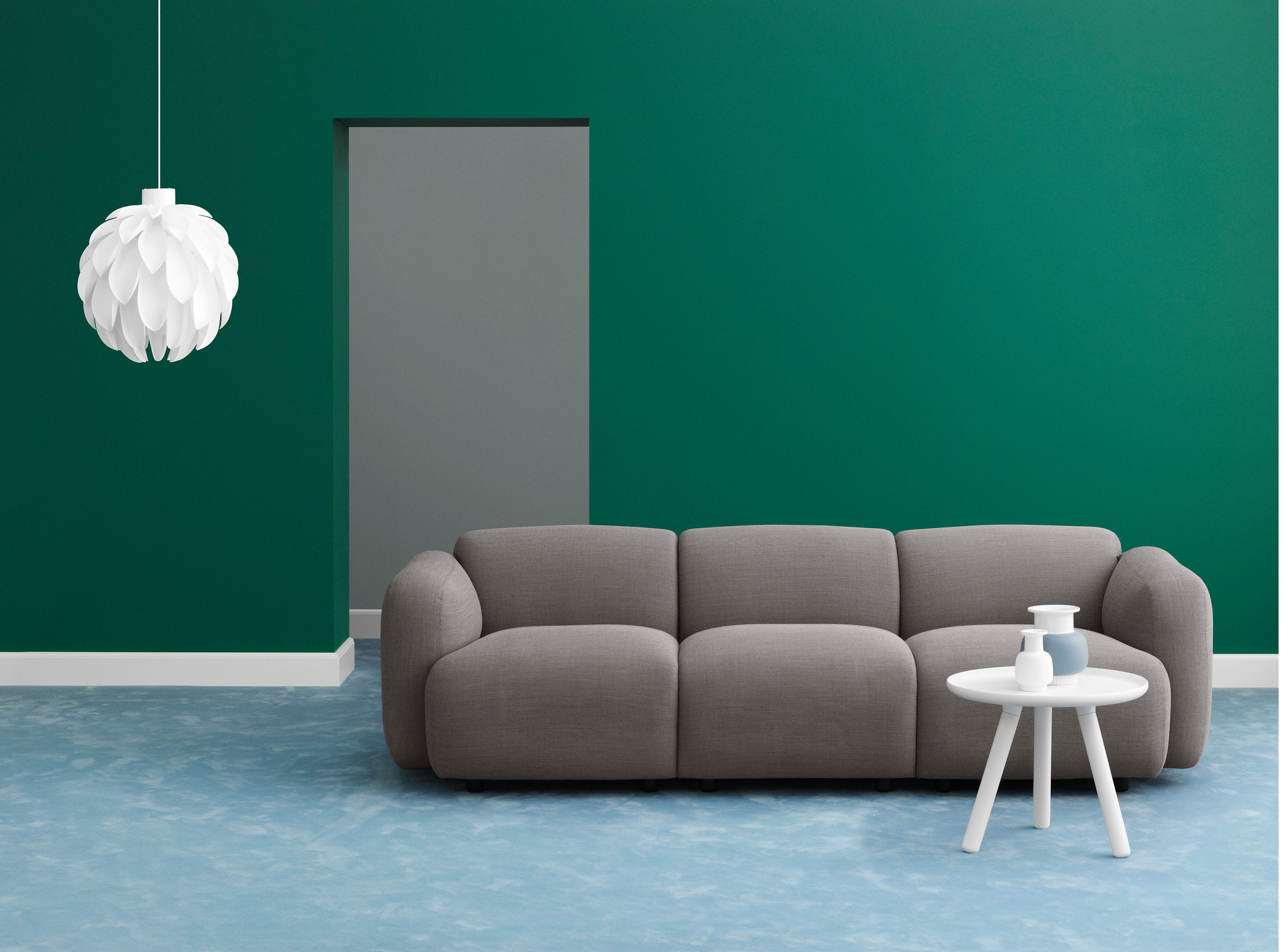 Normann Copenhagen Tablo Table Large Couchtisch in Weiß vor grauem Sofa und grüner Wand.