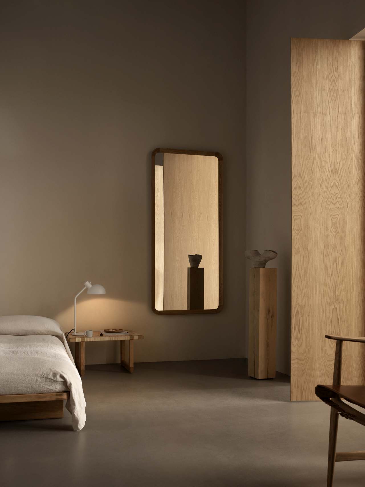 VLA62 Radio House Spiegel von Carl Hansen in Schlafzimmer mit Bett und Lampe.