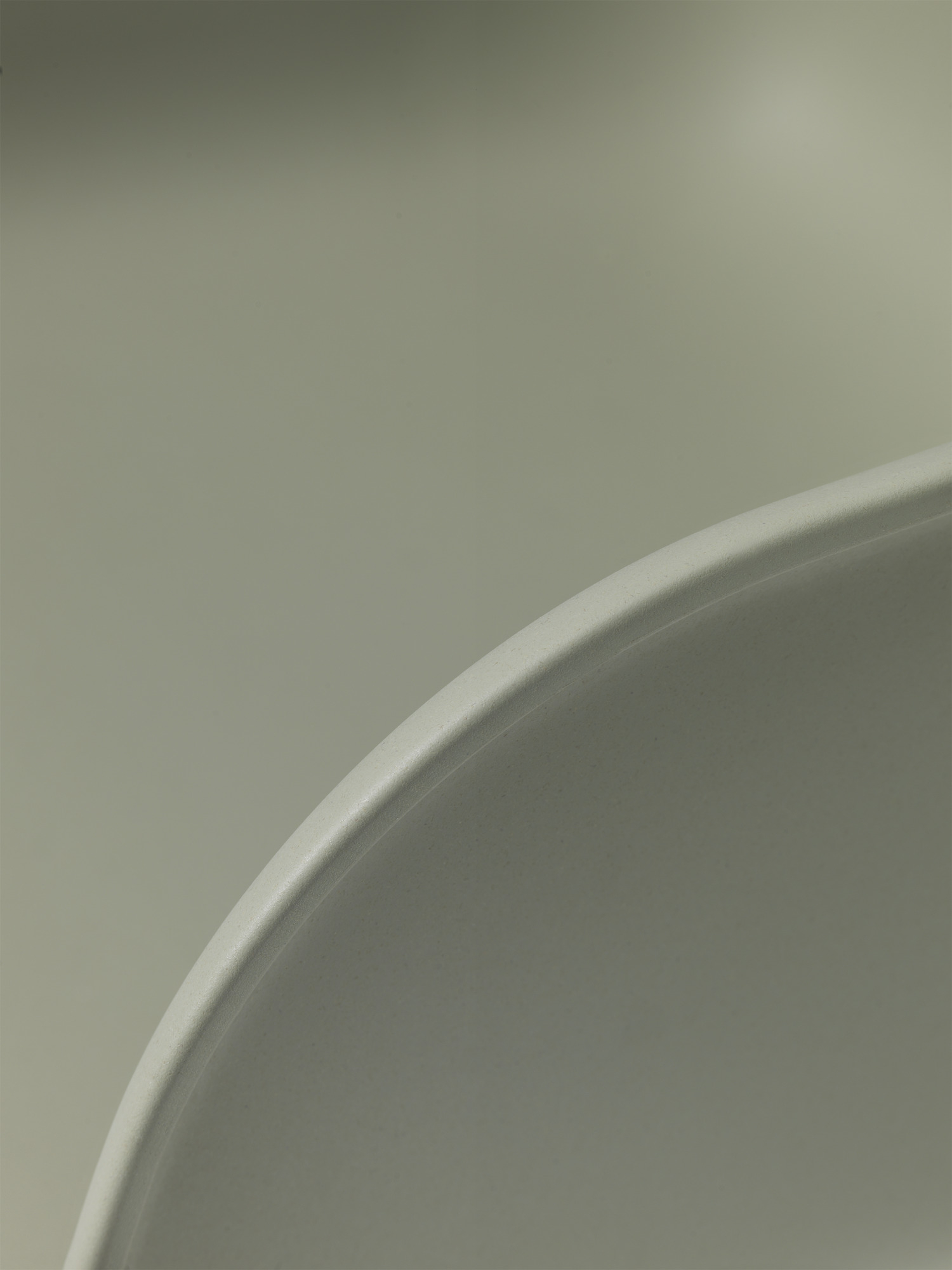 Detailaufnahme der Armlehne des grauen Fiber Armchair Stuhls von Muuto, modernes Möbeldesign.