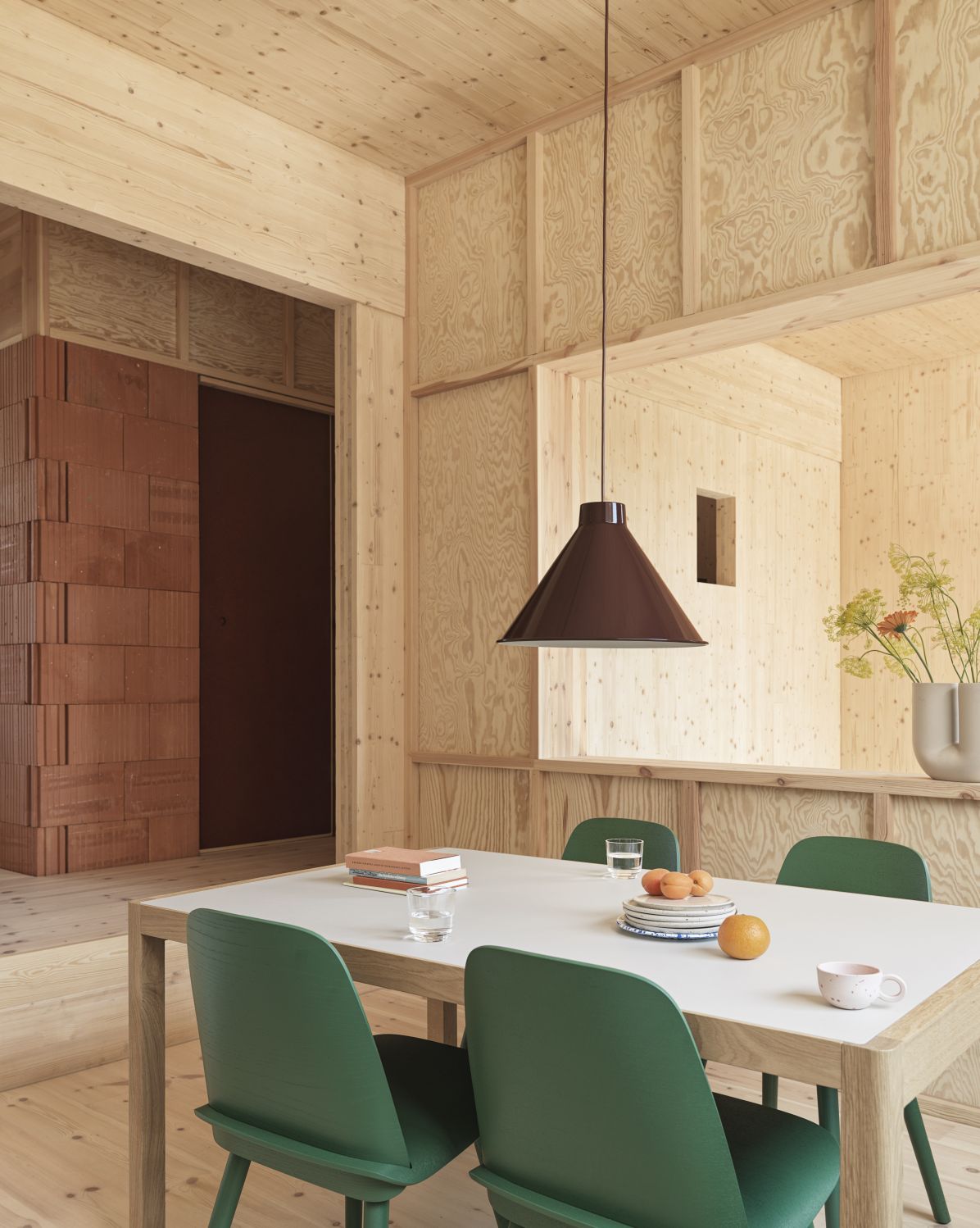 Moderne graue Muuto Pendelleuchte 36 cm über Esstisch mit grünen Stühlen in Holzküche.