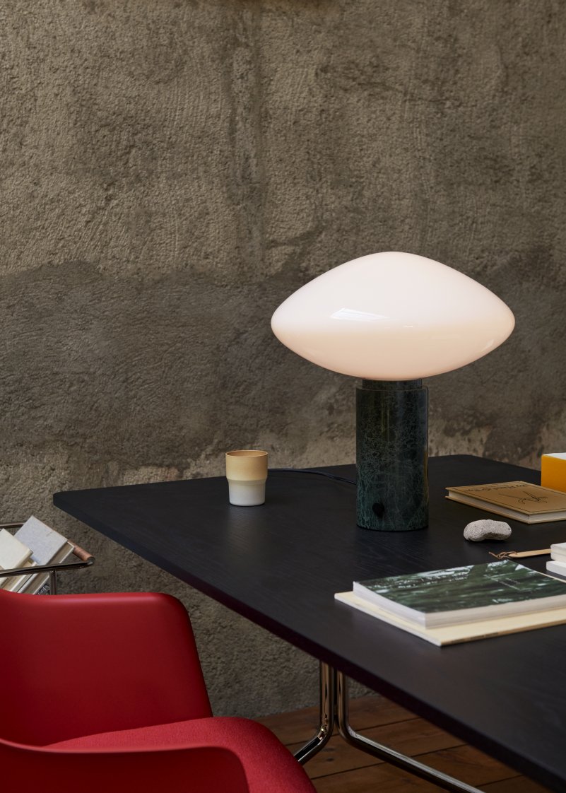 AndTradition Mist AP17 Tischleuchte Guatemale Verde auf schwarzem Schreibtisch, stimmungsvolle Beleuchtung für modernes Arbeitszimmer.