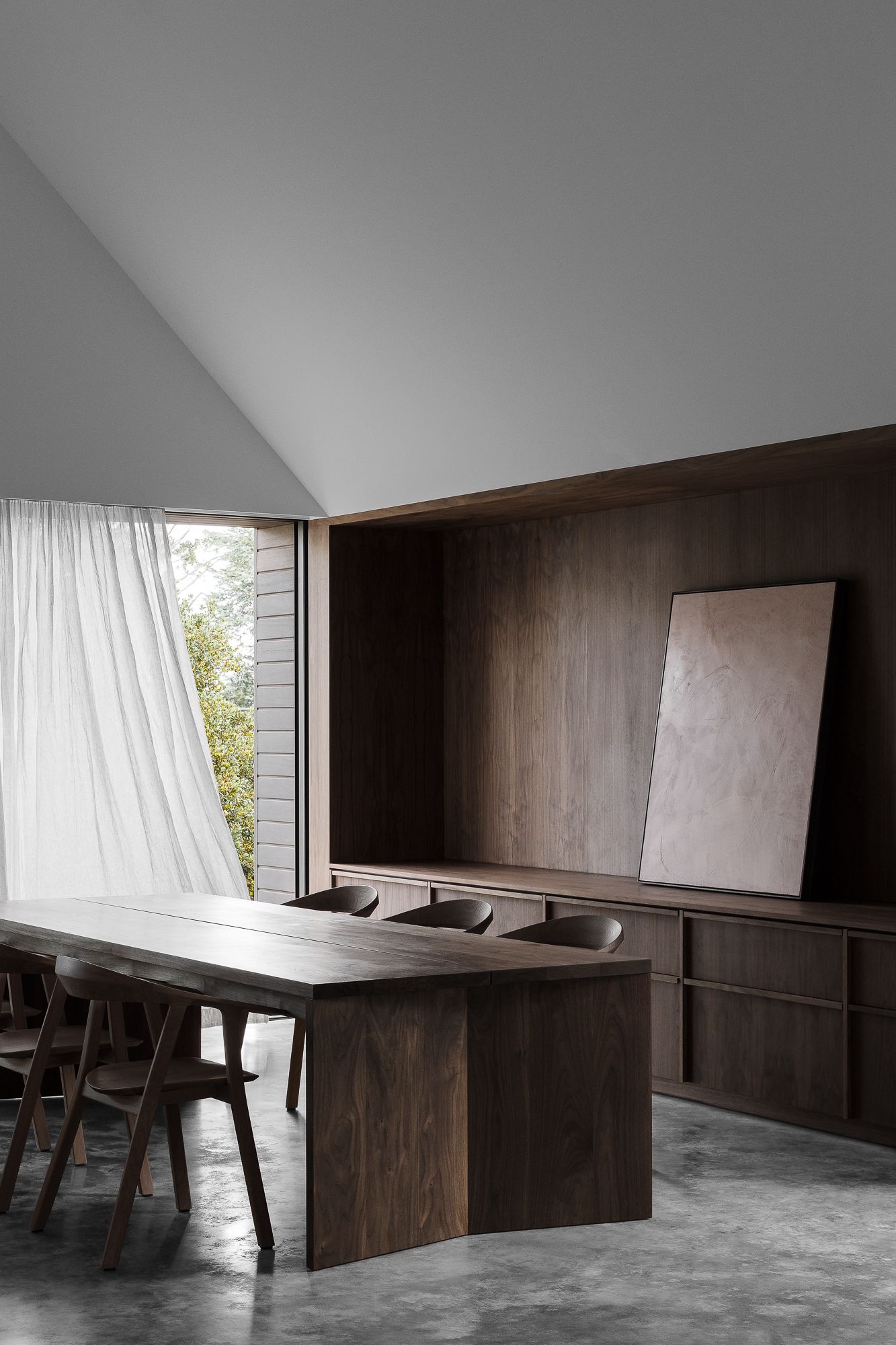 Innenaufnahme eines Esszimmers mit dunklem Holztisch, Rhomb Indoor Stühlen von Prostoria und passendem Sideboard.