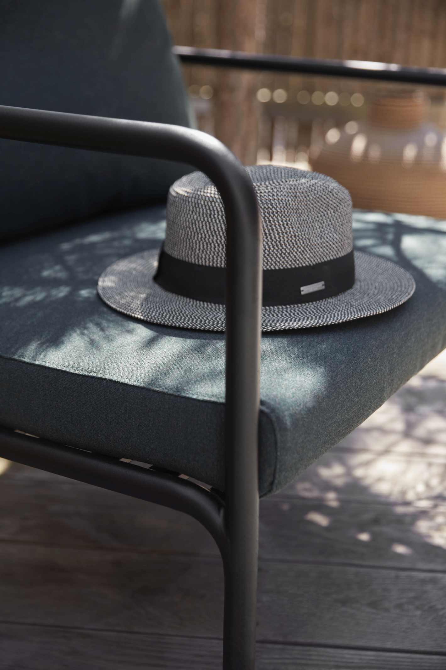 Nahaufnahme des Avon Lounge Chair Outdoor Sessels von Houe mit Hut auf der Sitzfläche.