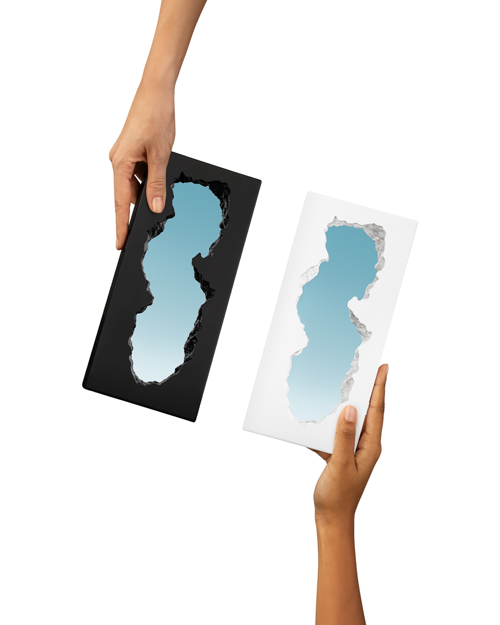 Zwei Hände halten Guframini Broken Mirror Miniaturen in Schwarz und Weiß. Designobjekt für moderne Wohnräume.