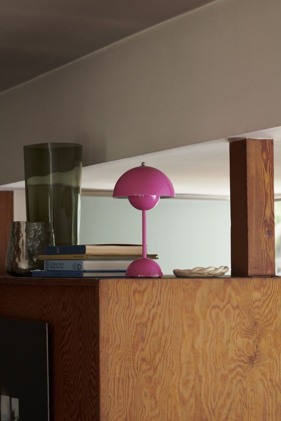 Flowerpot VP9 Tischleuchte in Tangy Pink von AndTradition auf einem Holzregal.