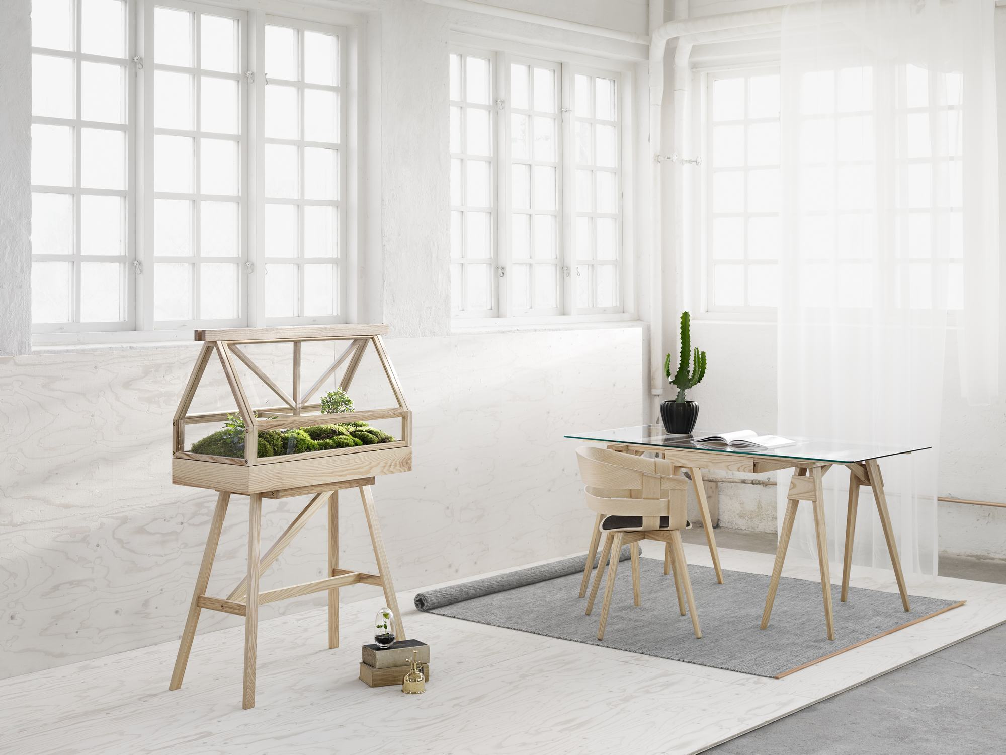 Design House Stockholm Gewächshaus "Greenhouse" mit Pflanzen auf Holzgestell in hellem Raum.