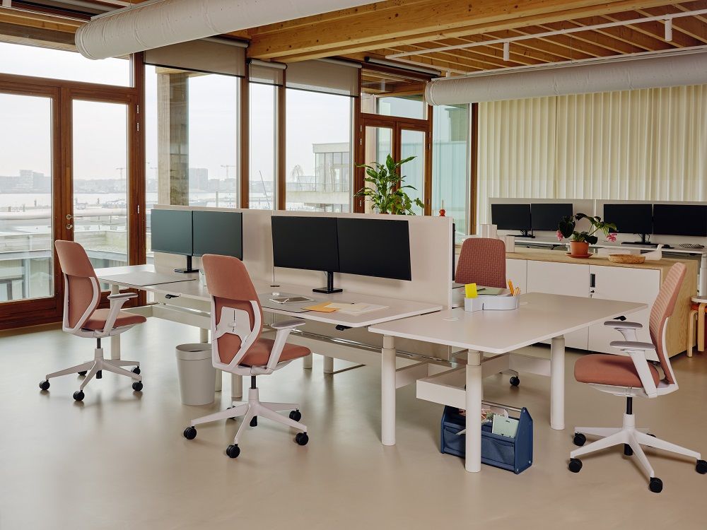 Büro mit mehreren ACX Soft Bürodrehstühlen von Vitra in Rosé und weißen Schreibtischen.