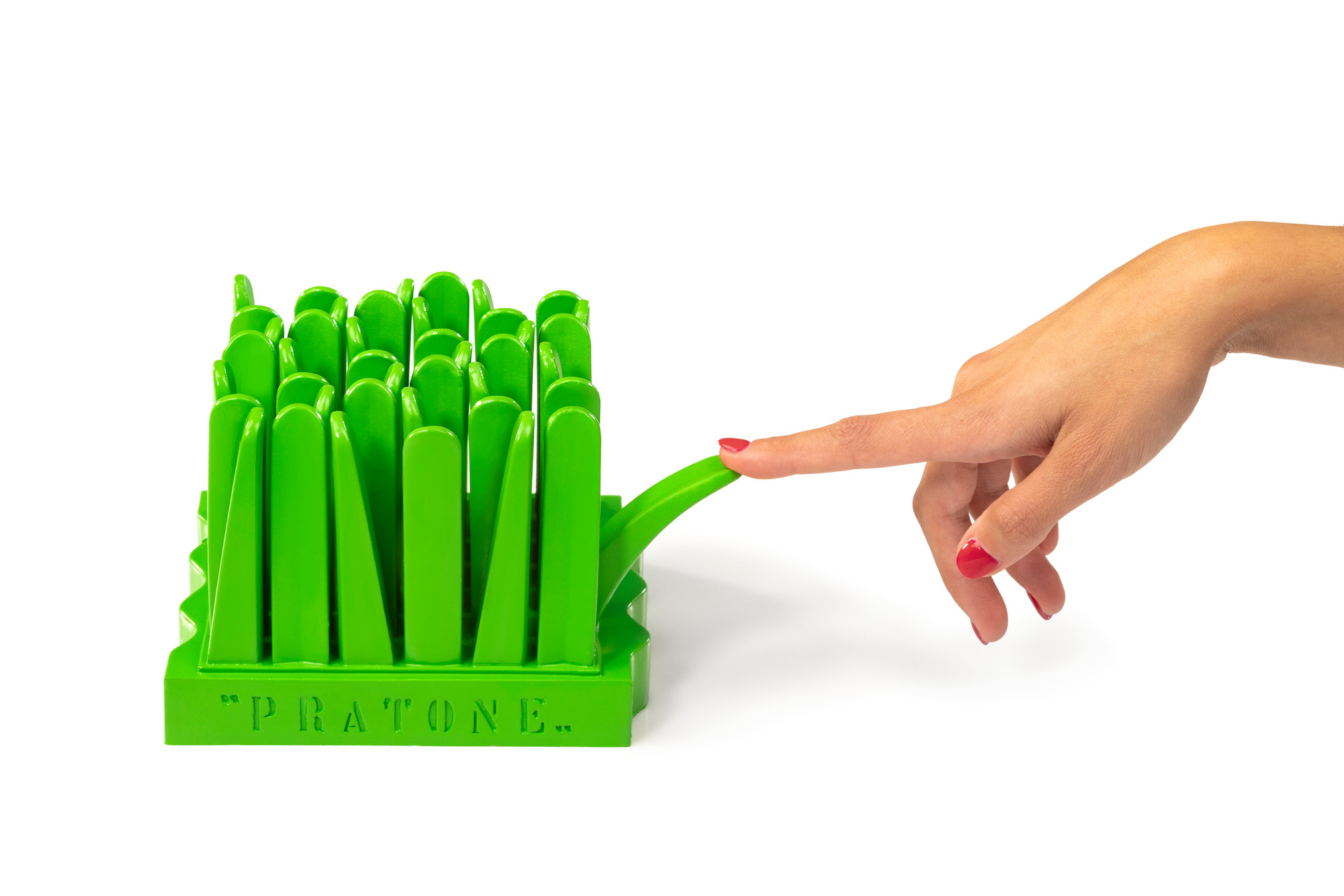 Grüne Gufram Pratone Miniatur Designikone, Finger berührt einen Grashalm. Designobjekt für Wohnaccessoires.