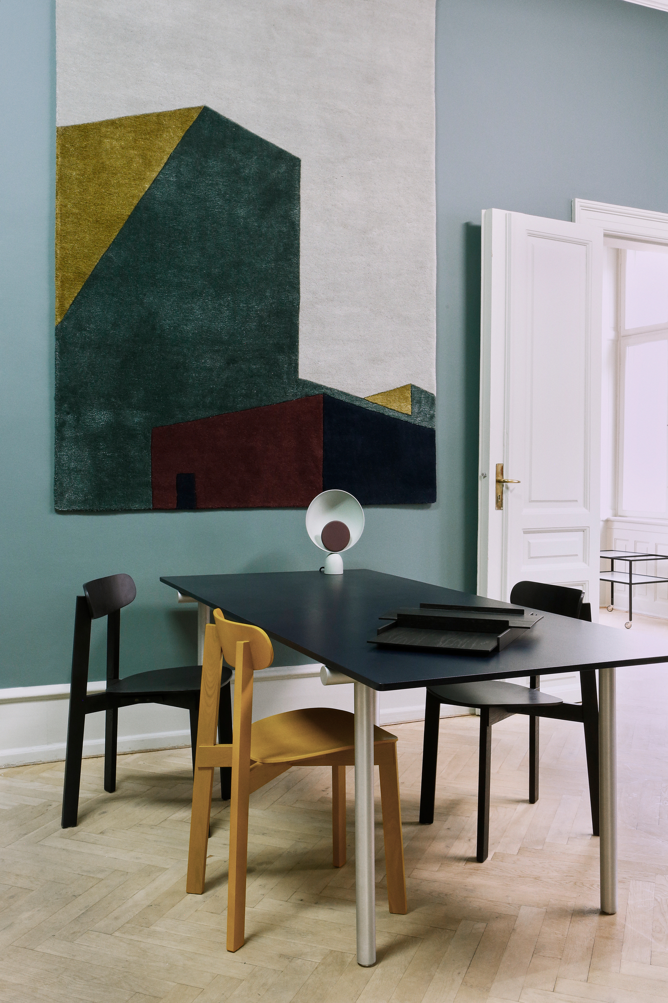 Arqui Teppich von Please Wait to be Seated mit abstraktem, geometrischem Muster an der Wand.