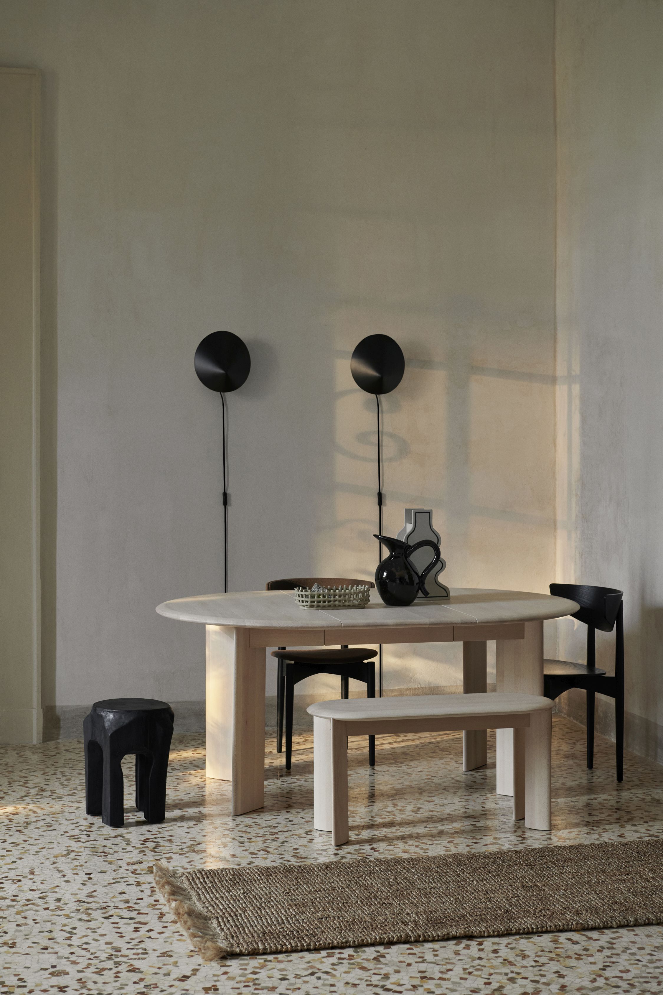 Ferm Living Bevel Bench Buche weiß geölt vor Esstisch mit Stühlen und Dekoration.
