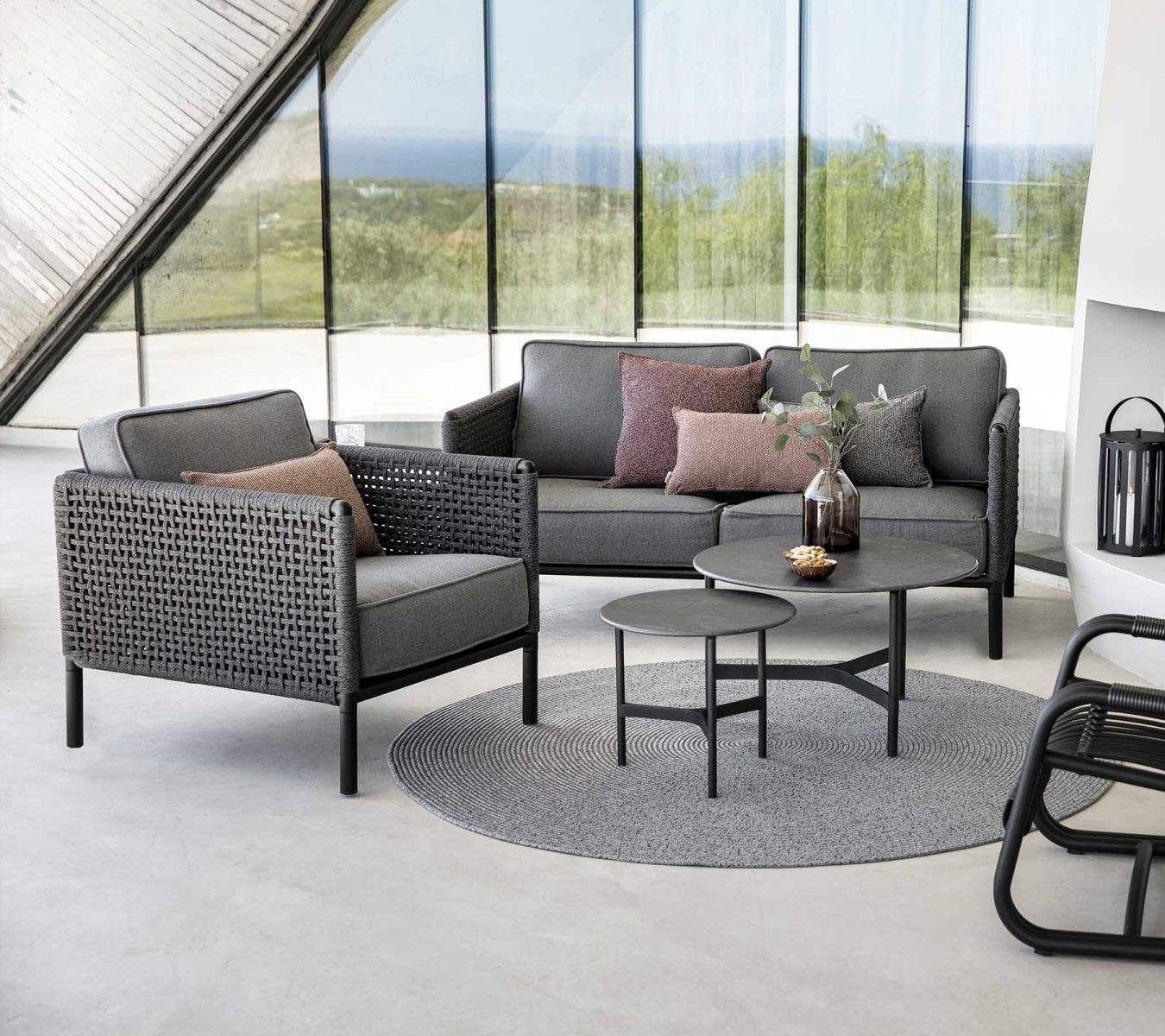 Graue Gartenmöbel-Lounge mit Sofa, Sessel, Tisch und Teppich für Terrasse oder Balkon.