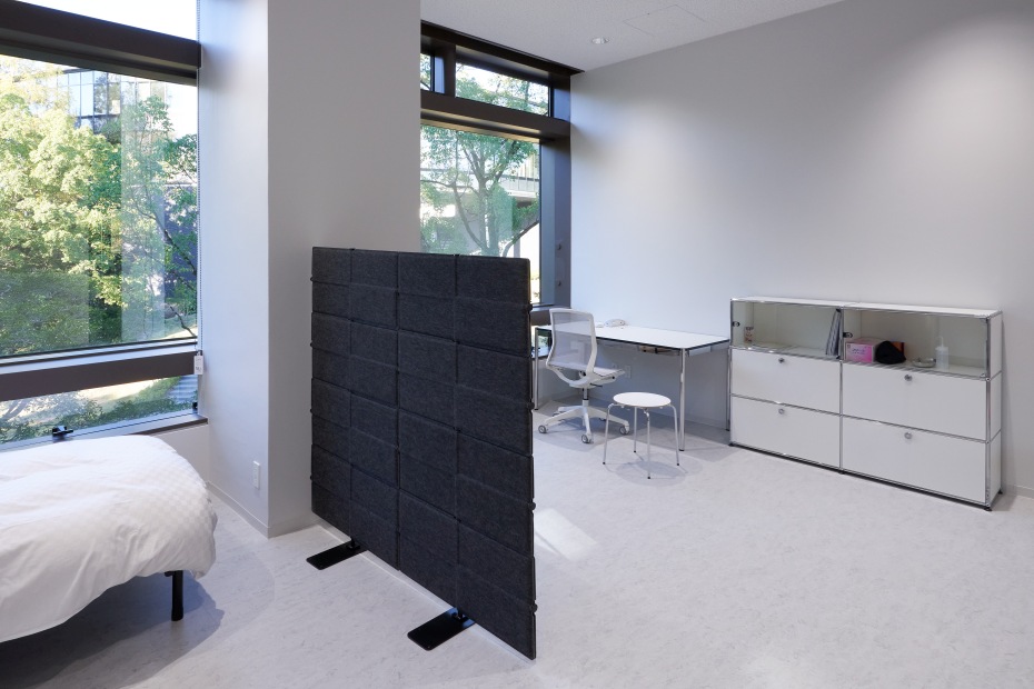 Grauer USM Haller Privacy Panel Raumteiler in modernem Büro mit Schreibtisch und USM Möbeln.
