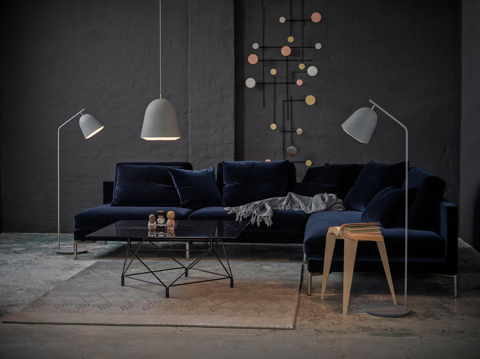 Moderne Wohnzimmer-Szene mit blauer Couch und zwei grauen Le Klint Cache Stehlampen für stimmungsvolle Beleuchtung.