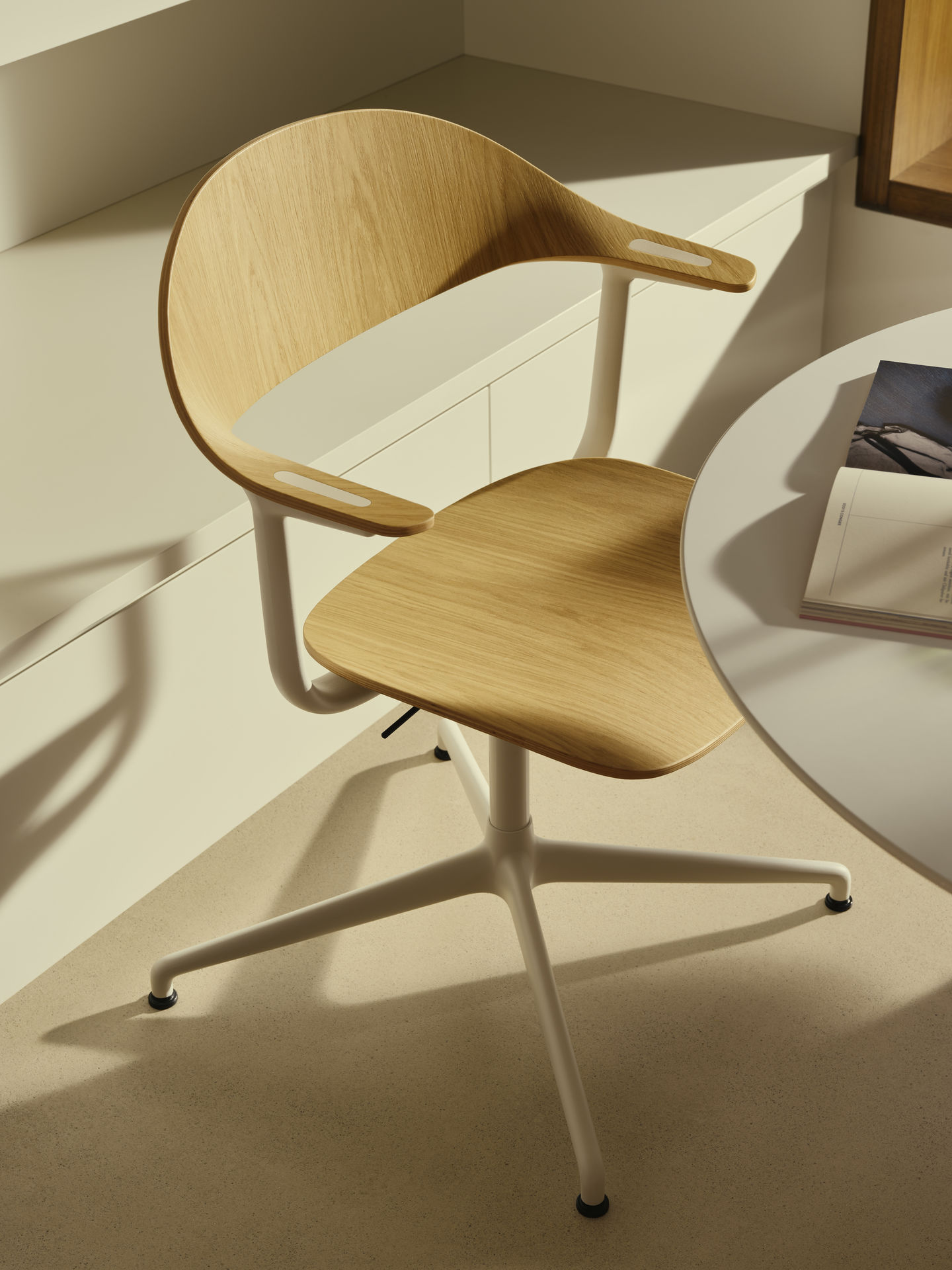 Mynt Bürodrehstuhl von Vitra mit hellem Holzfurnier und weißem Fußkreuz im modernen Büro.