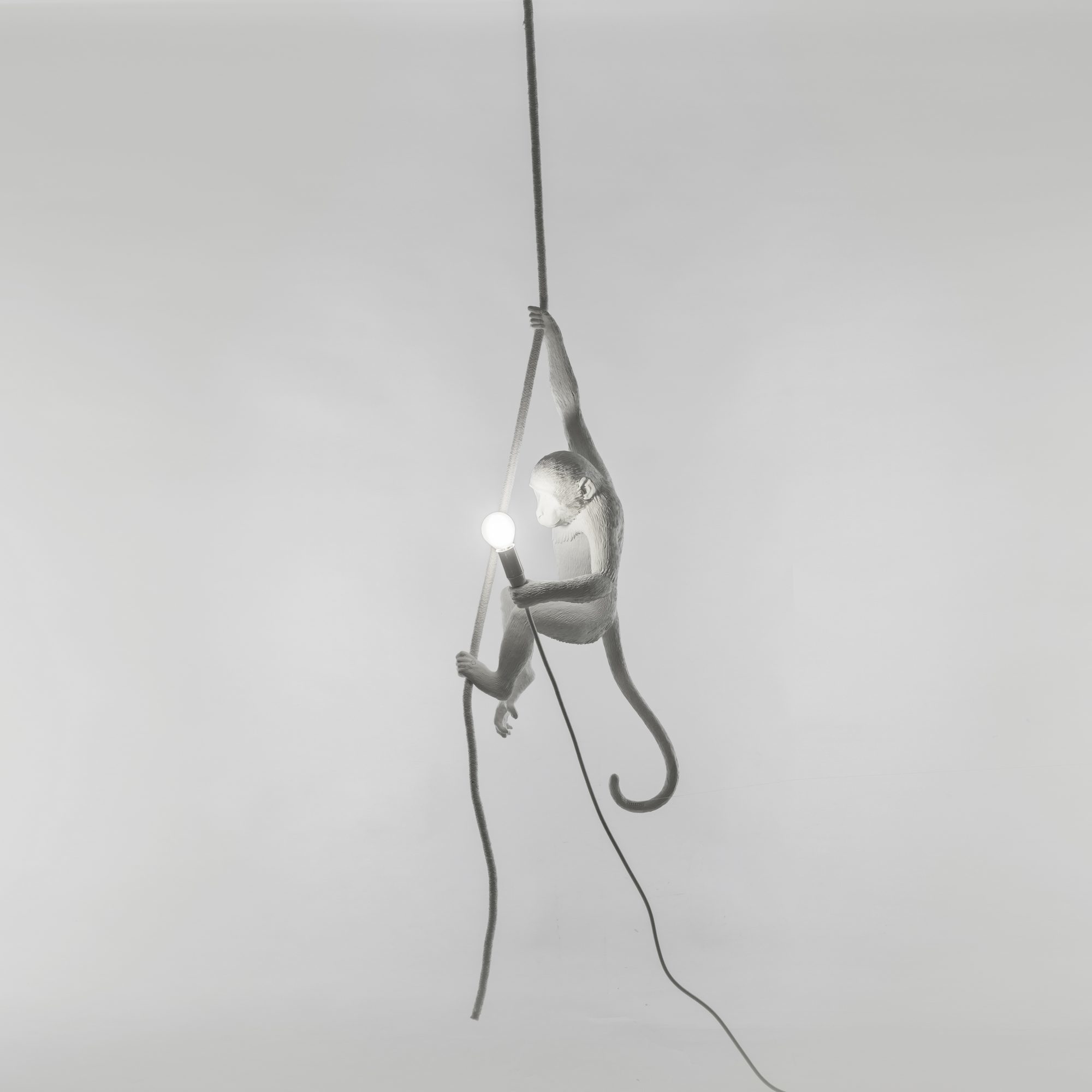 Weiße Monkey Lamp Pendelleuchte von Seletti, ein hängender Affe hält eine Glühbirne an einem Seil.