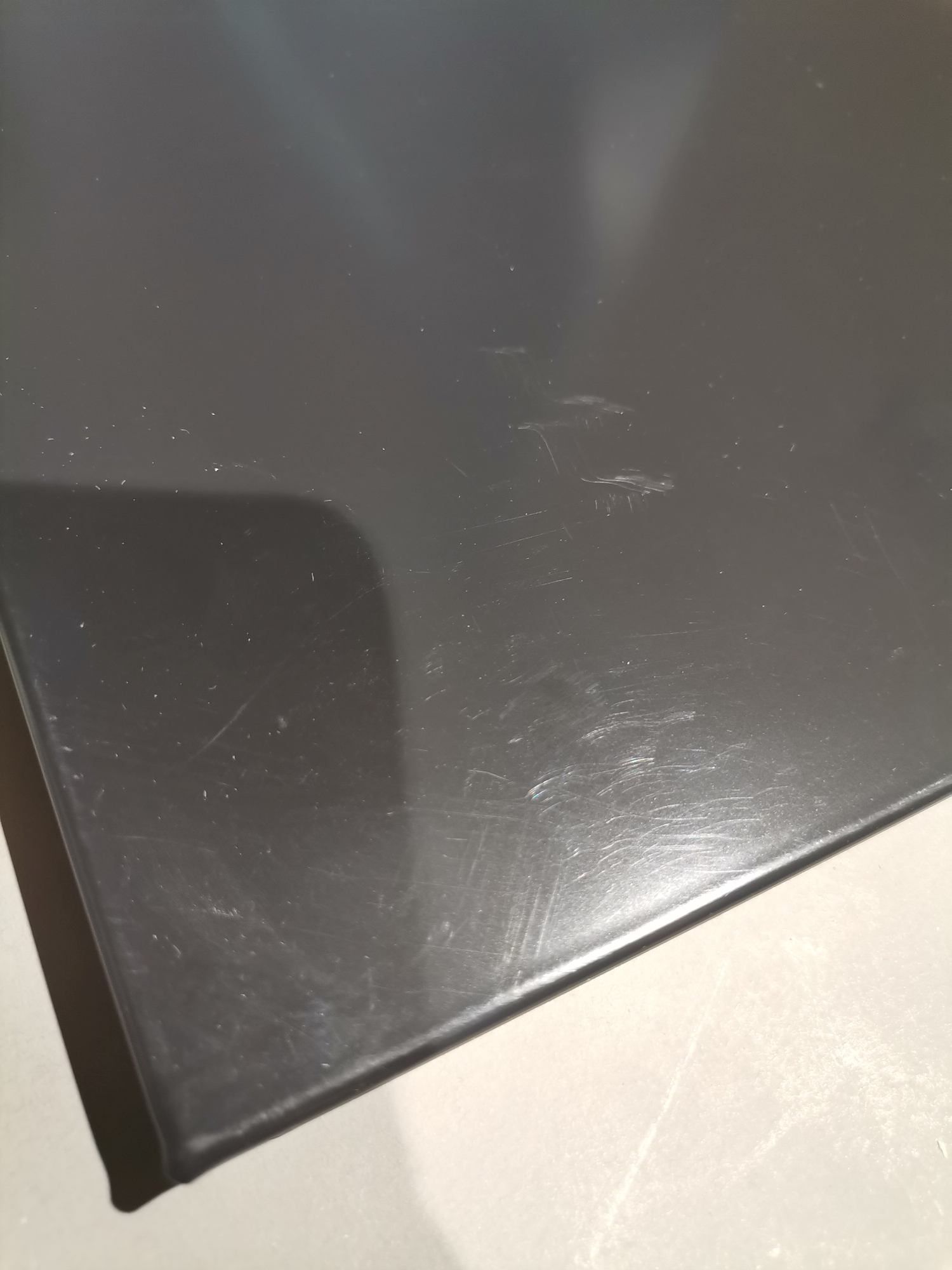 Detailaufnahme einer grauen USM Haller Tischplatte mit Kratzern und Gebrauchsspuren, Mängelexemplar.