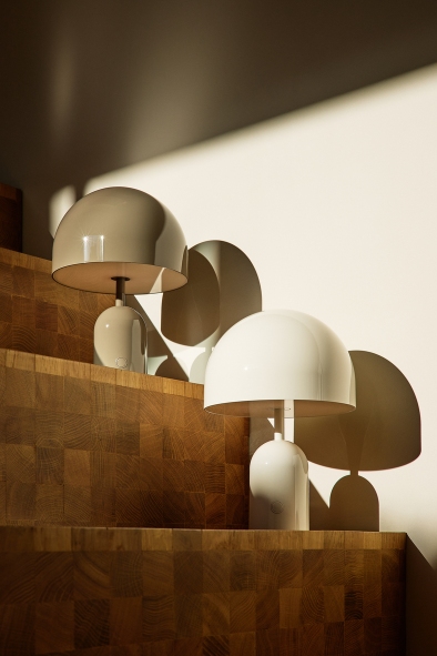 Zwei Tom Dixon Bell Tischleuchten: Eine goldene und eine weiße Akkuleuchte.