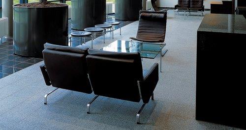 PK 31 Sofa von Fritz Hansen, schwarzes Ledersofa mit Stahlgestell und passendem Sessel im Wartebereich.
