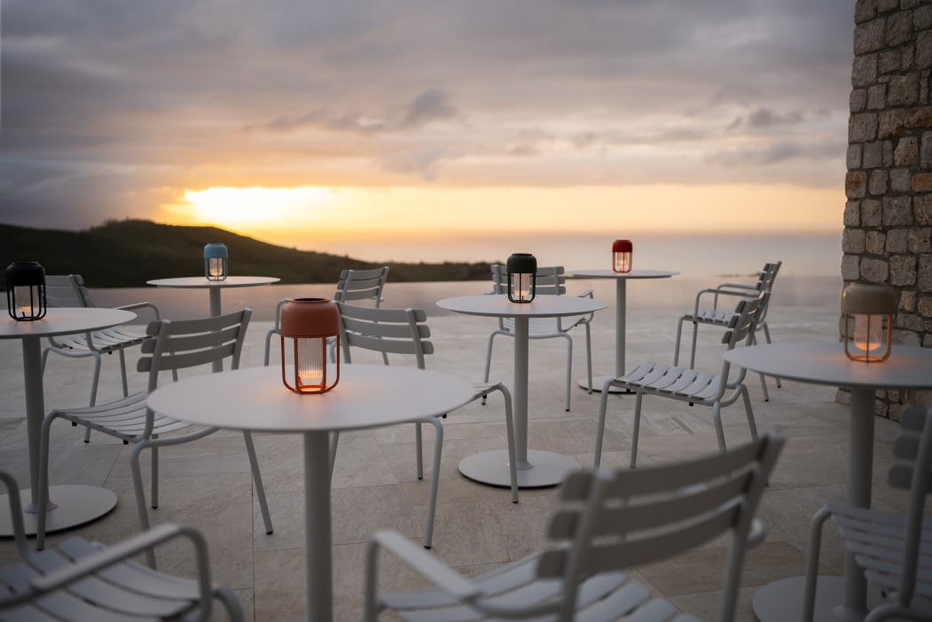 Alua Dining Chair von Houe, Outdoor-Stühle und Tische mit Laternen bei Sonnenuntergang.