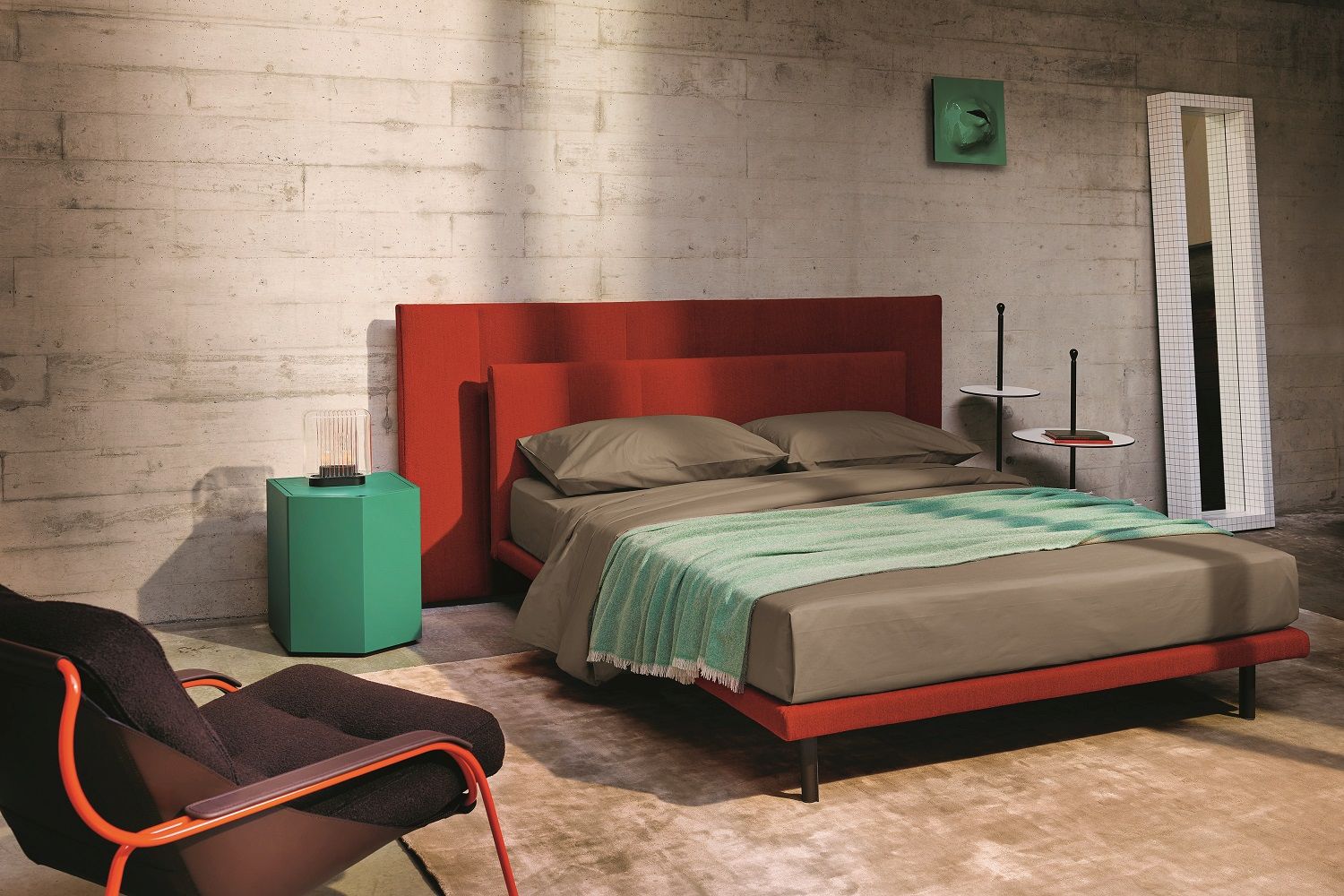 Zanotta Z24 Nachttisch in Grün neben rotem Bett in modernem Schlafzimmer mit Designermöbeln.
