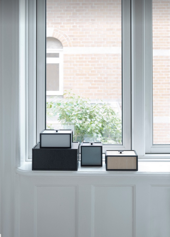 Audo Frame Aufbewahrungsboxen in verschiedenen Farben und Größen auf einer Fensterbank, stilvolle Wohnraumorganisation.
