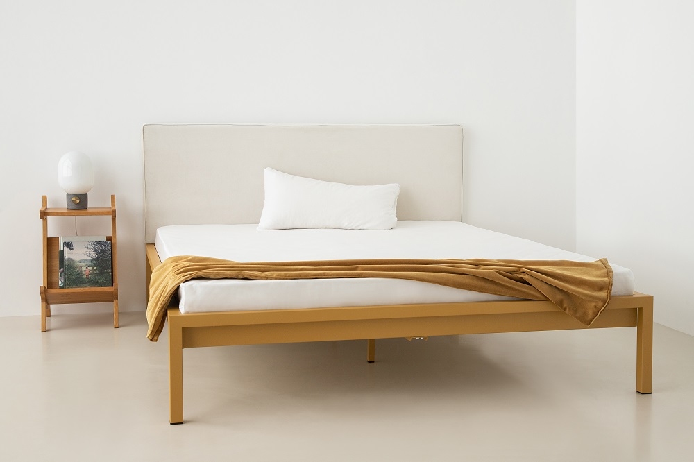 Pure Bett von Hans Hansen, Stahl pulverbeschichtet in Sand Gold mit Polsterkopfteil und Nachttisch.